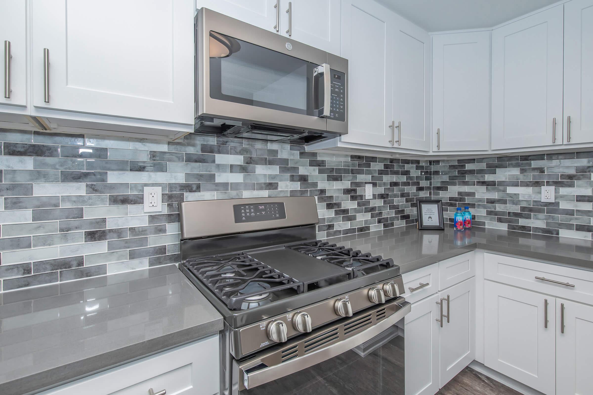 a stove top oven sitting inside of a kitchen