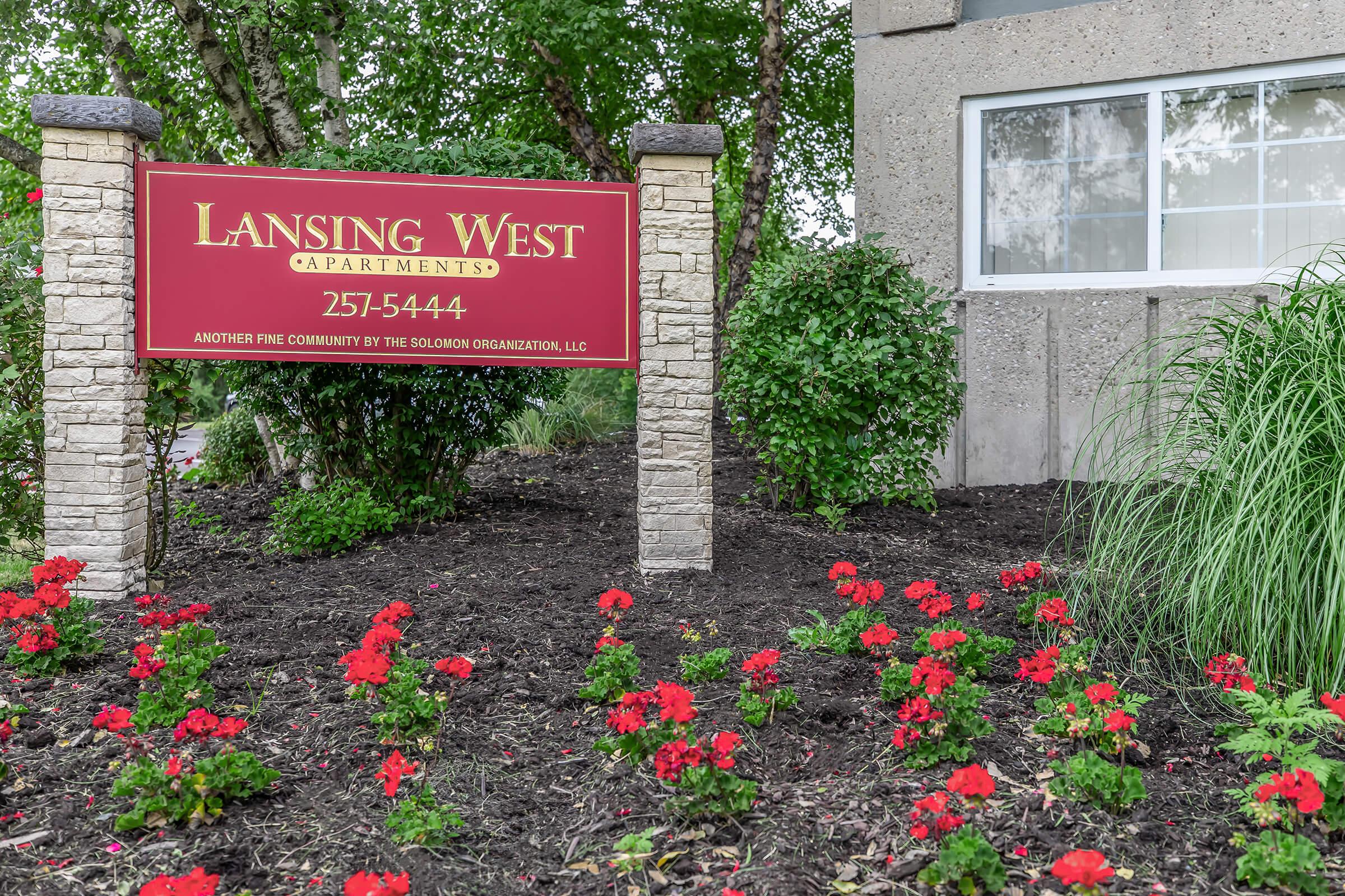 a sign in front of a flower garden