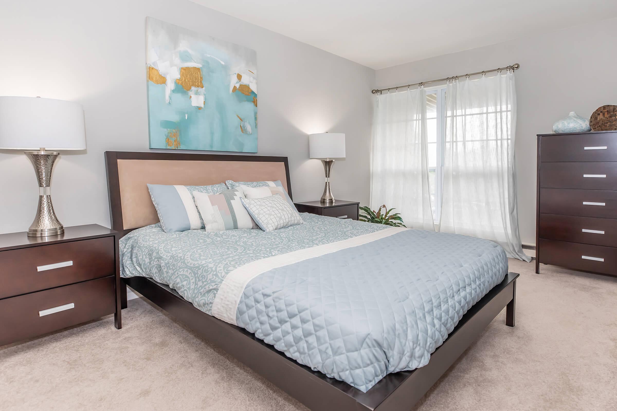 a bedroom with a bed and desk in a hotel room