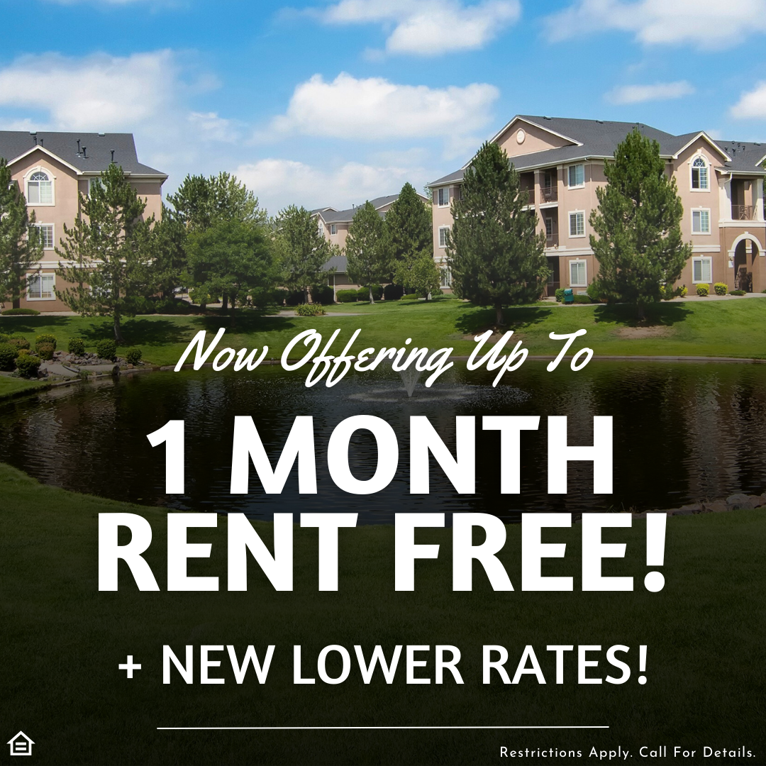 Photo of apartment community exterior behind a pond with a fountain surrounded by green grass and trees. overlaying text saying "now offering up to 1 month rent free! + new lower rates! restrictions apply. call for details.