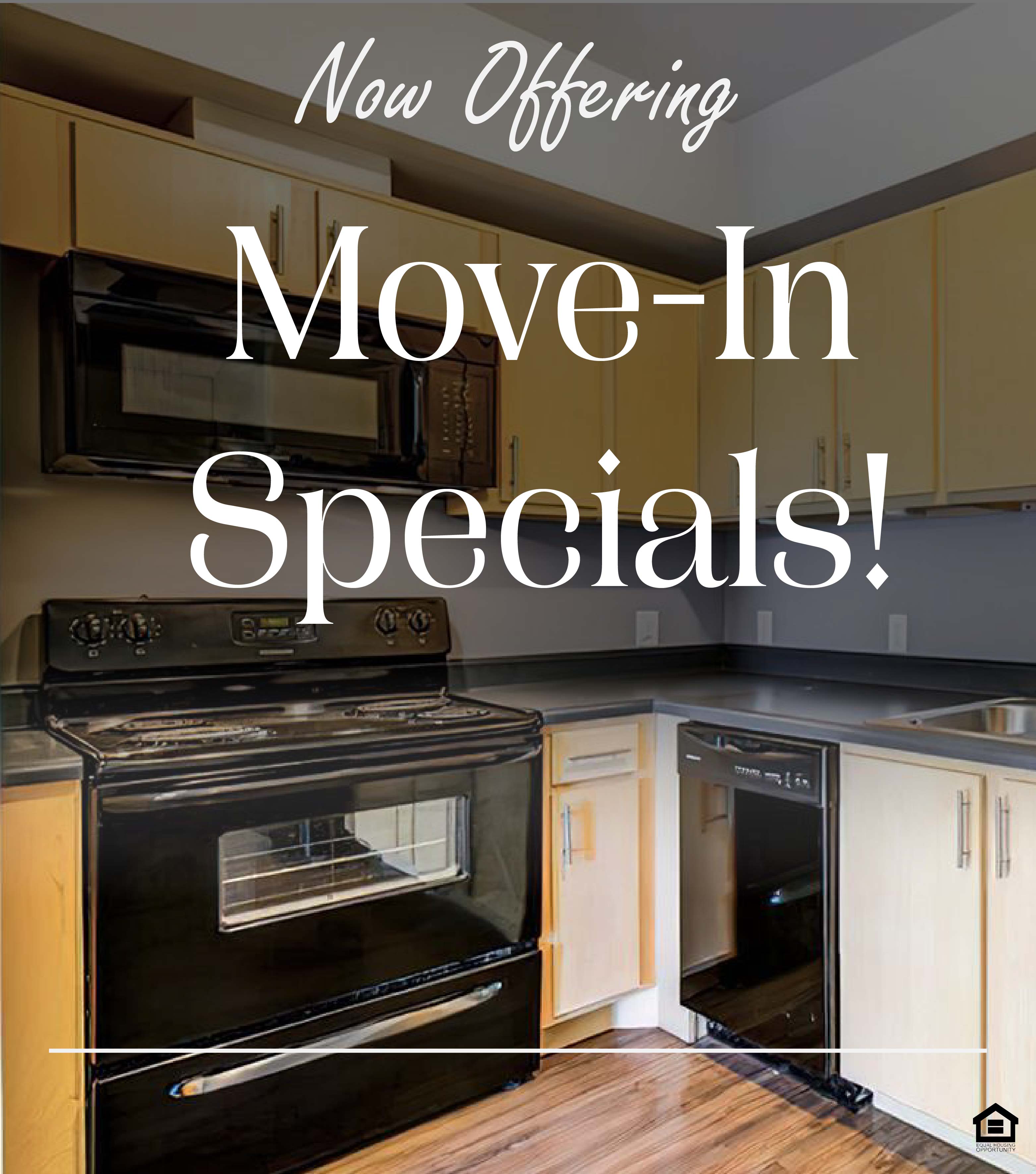 Modern kitchen featuring wooden cabinets and blackappliances. Includes a black refrigerator, oven, and microwave, with a double sink and dishwasher. The text on the image says, "Now offering move-in specials!"