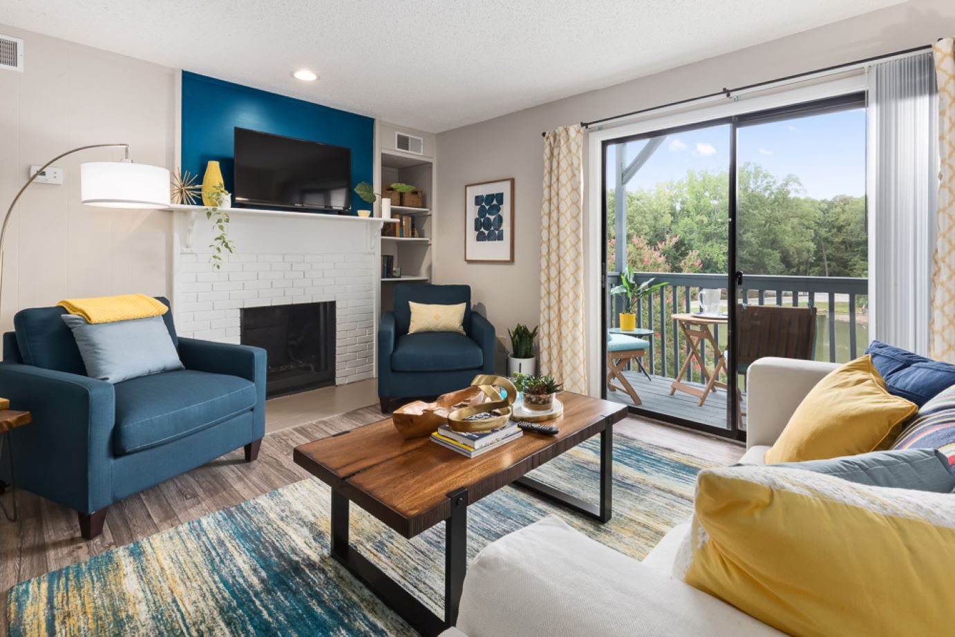 Living room with a fireplace and TV at Edgewater Village Apartments in Greensboro, NC