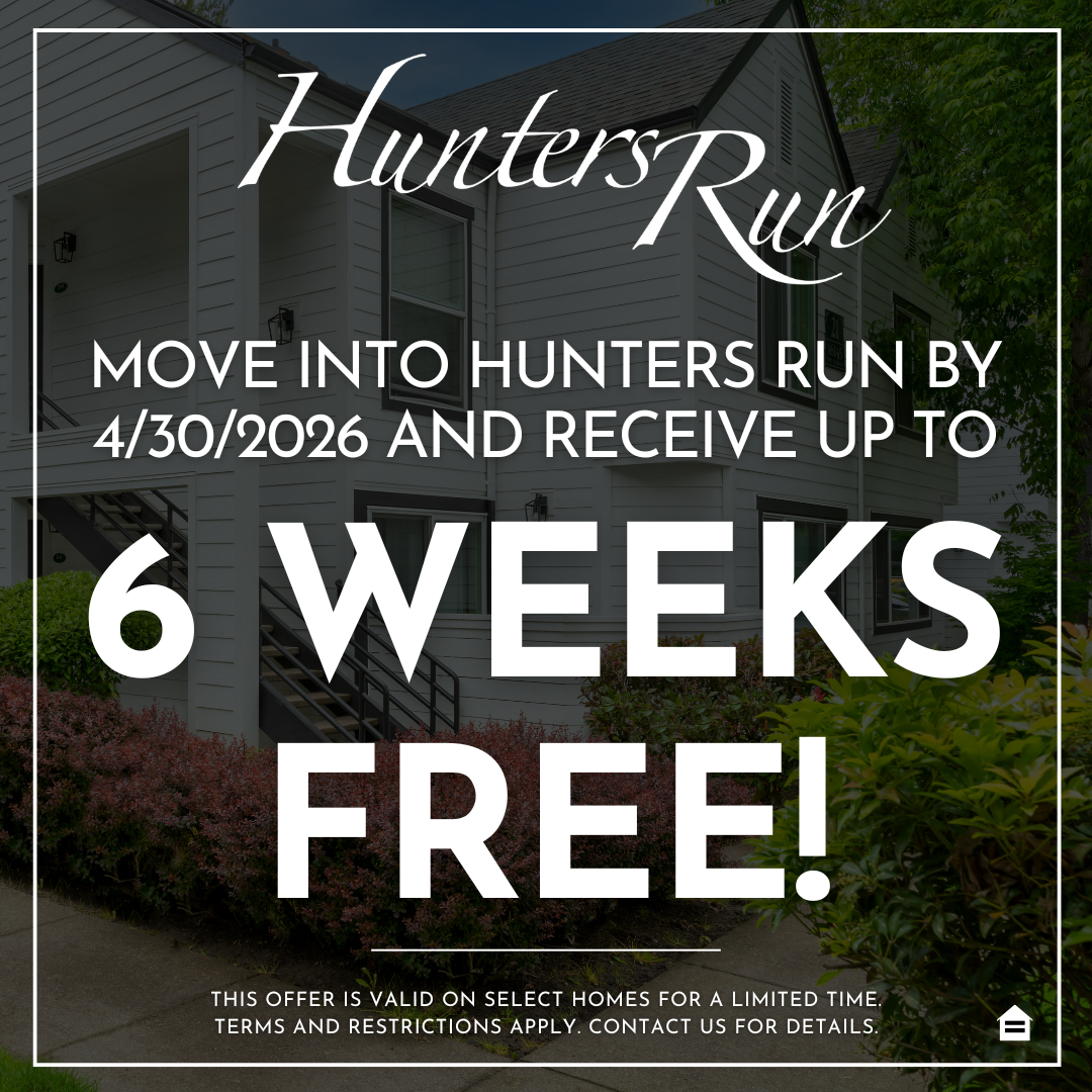 Promotional graphic featuring a background photo of a white apartment building with black trim, exterior stairs, and green landscaping. The 'Hunters Run' logo appears in white script at the top. Overlaid text reads, 'Move into Hunters Run by 4/30/2026 and receive up to,' followed by large, bold white text stating, '6 WEEKS FREE!' Fine print at the bottom states, 'This offer is valid on select homes for a limited time. Terms and restrictions apply. Contact us for details,' alongside an Equal Housing Opportun