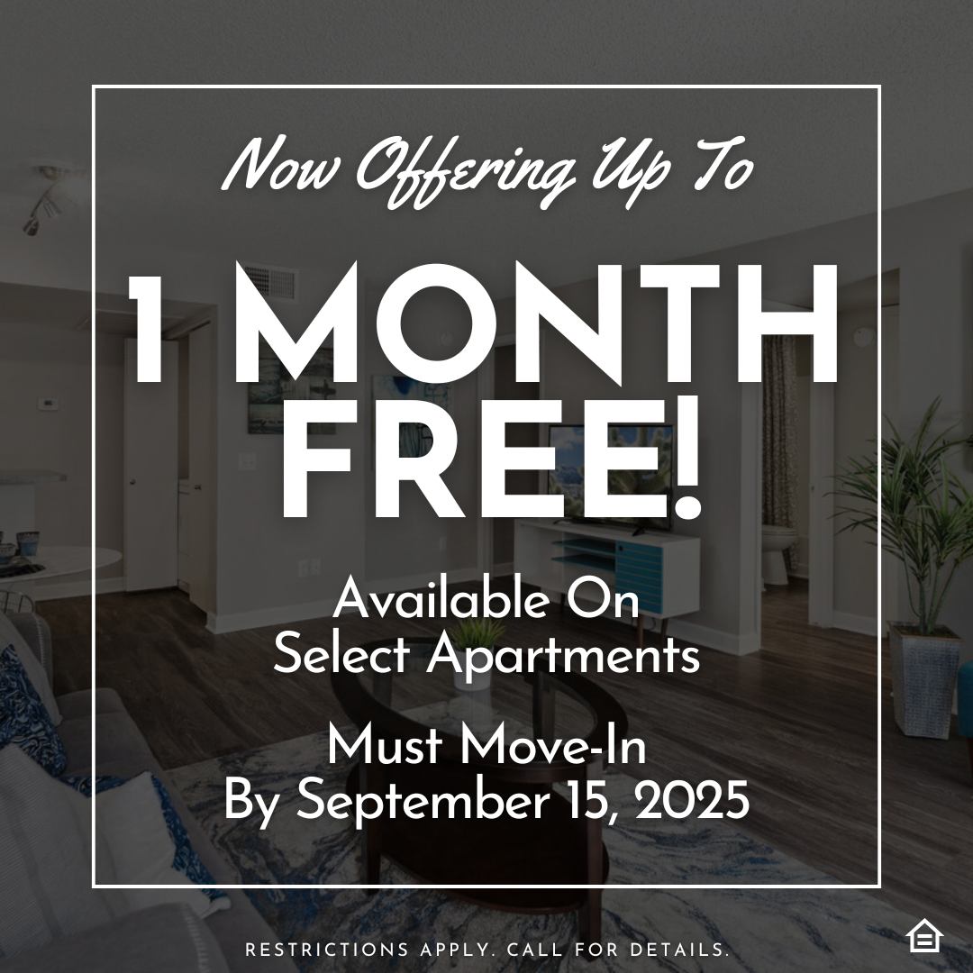 A modern living room with a gray sofa adorned with blue cushions. There’s a round coffee table in front, and a flat-screen TV on a white console. The text on the image says "Now offering up to 1 month free! Available on select apartments. Must move-in by September 15, 2025"