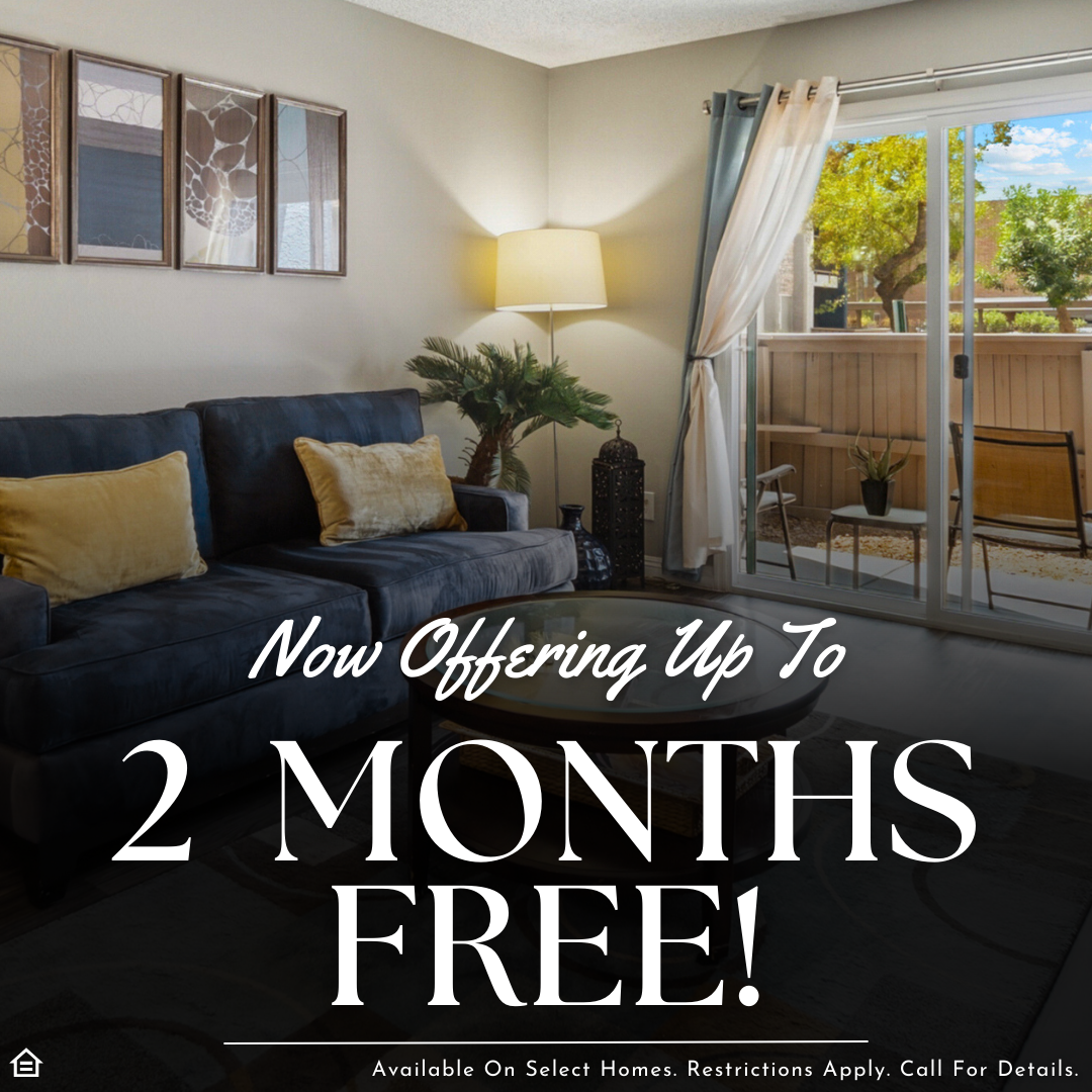 Promotional graphic featuring a photo of a cozy living room with a blue sofa, yellow pillows, and a sliding glass door leading to a patio. Large, white text overlaid on the image reads, 'Now Offering Up To 2 MONTHS FREE!' Fine print at the bottom states, 'Available On Select Homes. Restrictions Apply. Call For Details,' located next to an Equal Housing Opportunity icon.