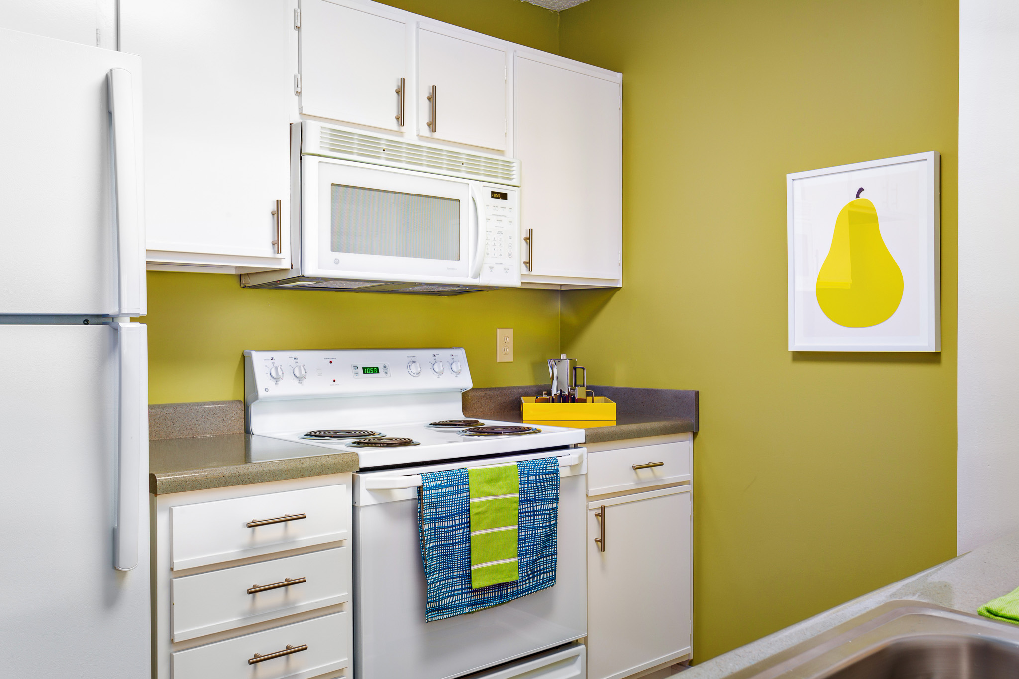 A kitchen with white cabinets and a microwave at Ashley Oaks Apartments in Greensboro, NC