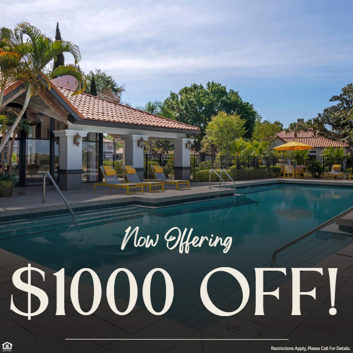 Picture of an apartment community pool with palm trees and seating. Now offering $1000 off. Restrictions apply, please call for details.