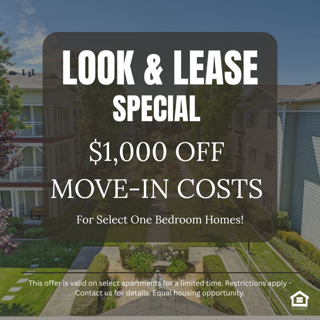 View of a residential complex featuring well maintained landscaping with green lawns flowering plants and trees The buildings are two to three stories high surrounded by pathways and communal areas all under a clear blue sky text reads look and lease special $1000 off move in costs for select one bedroom homes Equal housing opportunity