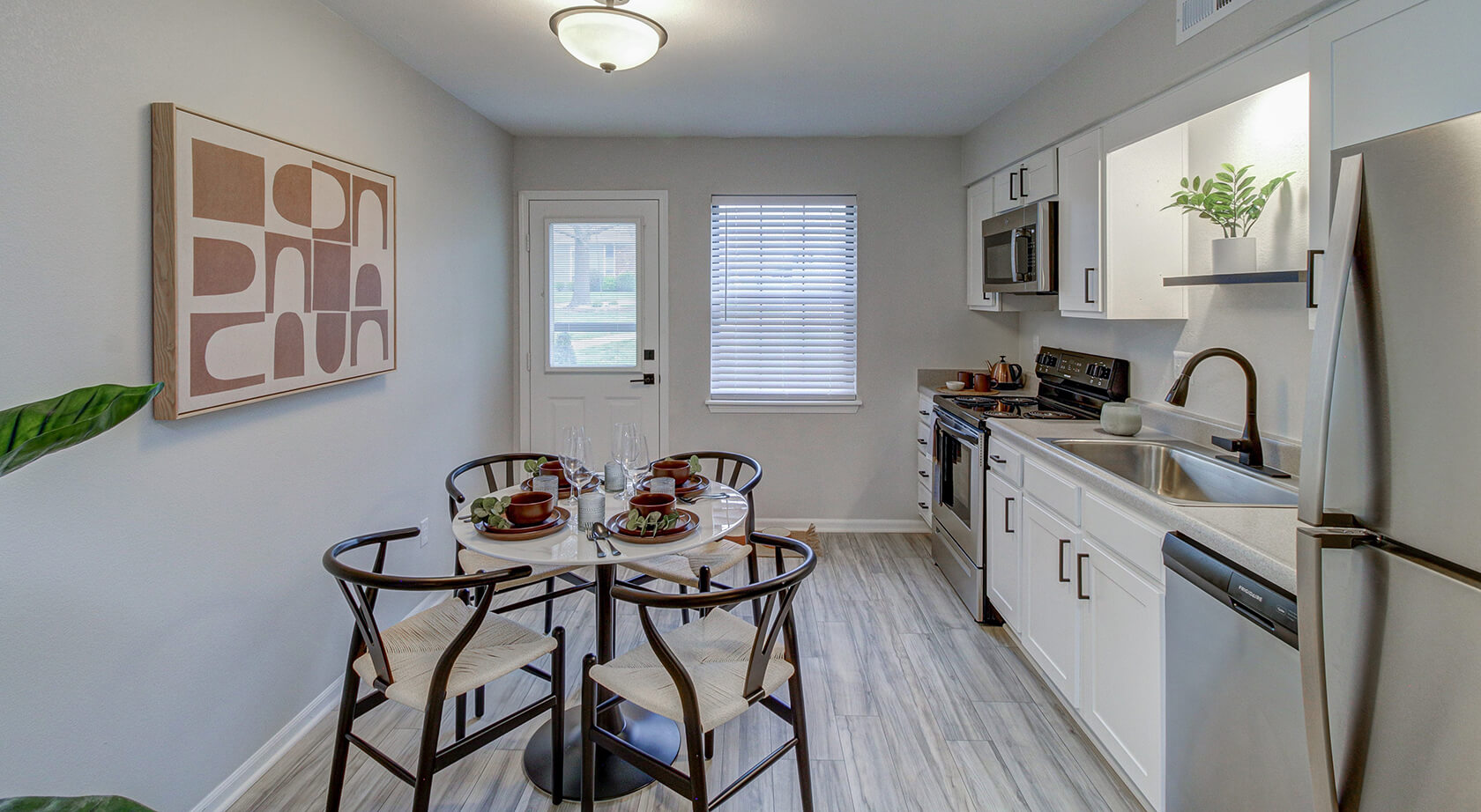 A kitchen with a table and chairs at The Arbor Apartments in Blue Springs, MO
