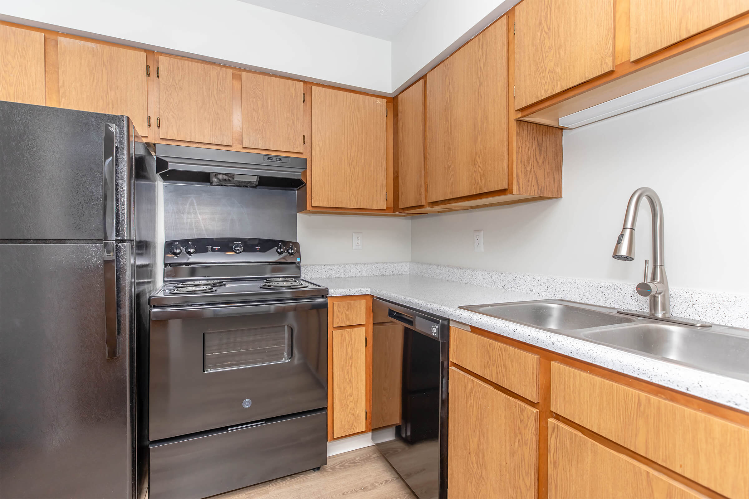 A kitchen with wooded cabinets and a stove at Lakeview Apartments in Franklin, Indiana