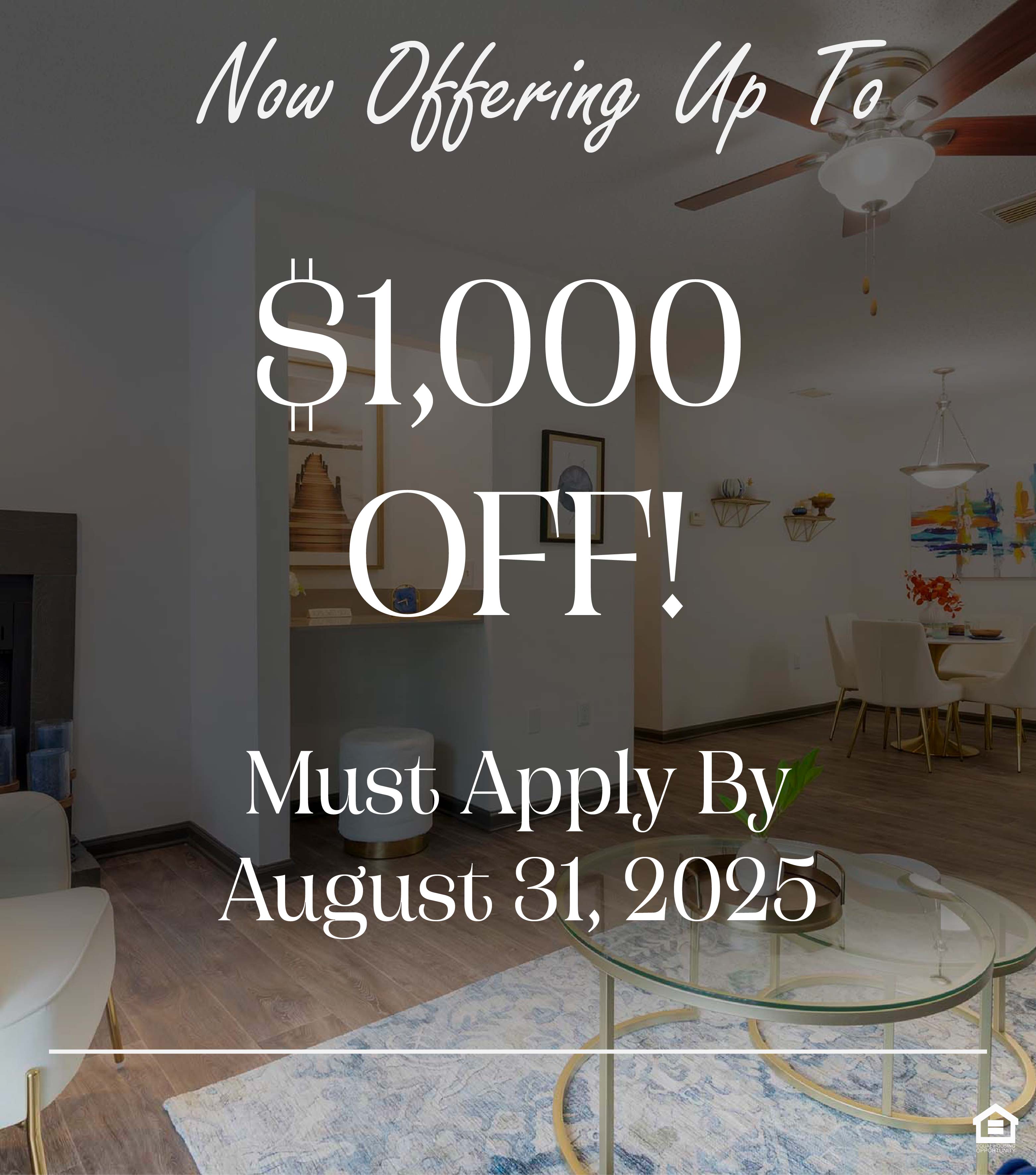 A cozy living room featuring a white armchair with a brown throw, a glass coffee table on a blue area rug, and a blue sofa. There's a fireplace, a round wall mirror, and a small dining area visible in the background with a pendant light and decorative artwork. The text on the image says, "Now offering up to $1,000 off! Must apply by August 31, 2025."