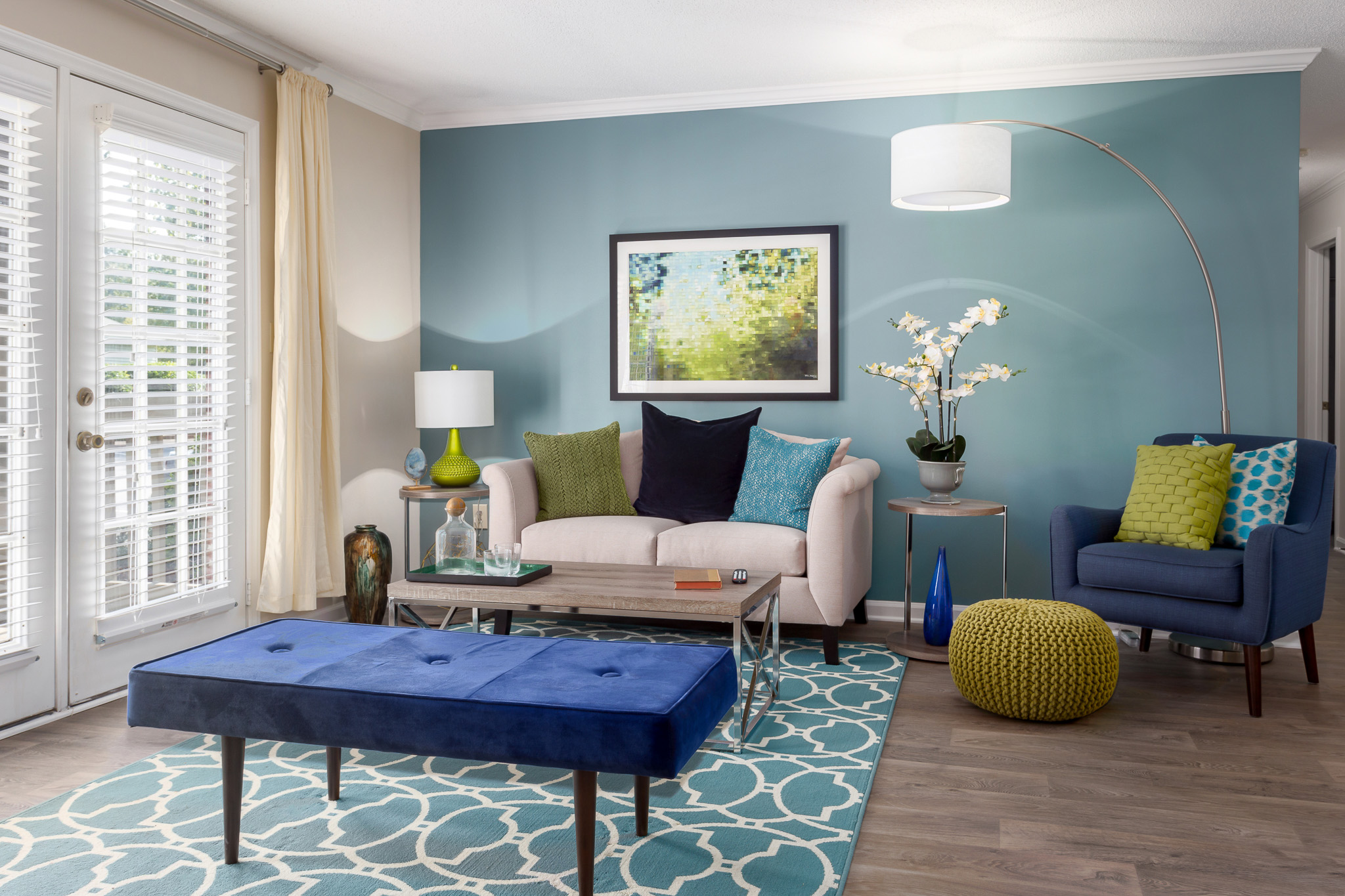 A living room with blue walls and a blue ottoman at Ashley Oaks in Greensboro, NC