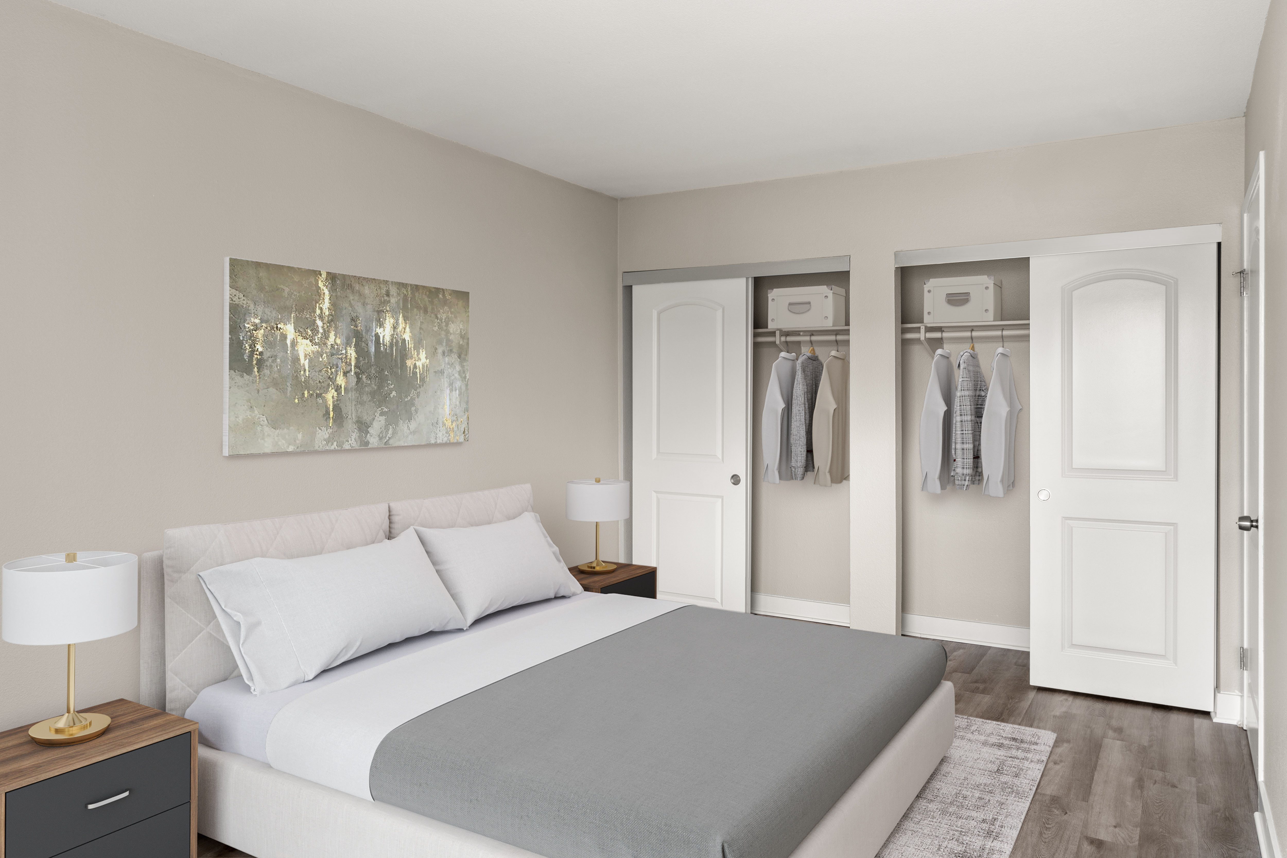 a bedroom with a large bed between two nightstands with lamps, in front of abstract hanging wall art, and two closets containing hanging shirts