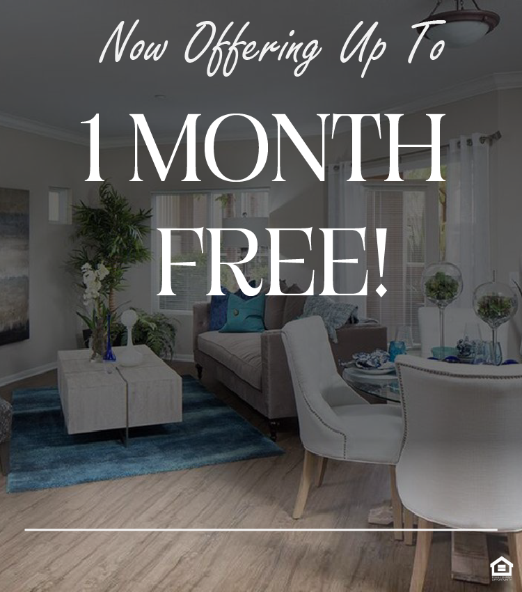 A modern living room featuring a light color scheme with beige walls and hardwood flooring. The space includes a comfortable gray sofa, a round dining table with white chairs, a decorative coffee table, and various plants. Decorative accents in blue and white enhance the tranquil atmosphere. The text on the image says, "Now offering up to 1 month free!"