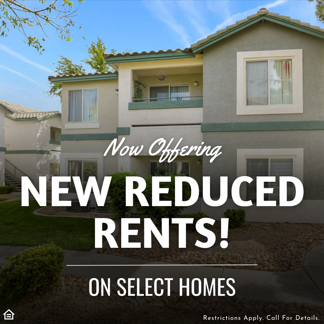 Exterior view of a beige and green two-story apartment building with balconies and large windows, surrounded by landscaping. Overlaid text reads “Now Offering NEW REDUCED RENTS! On Select Homes.” Small print at the bottom says, “Restrictions Apply. Call For Details.” A fair housing logo appears in the corner.