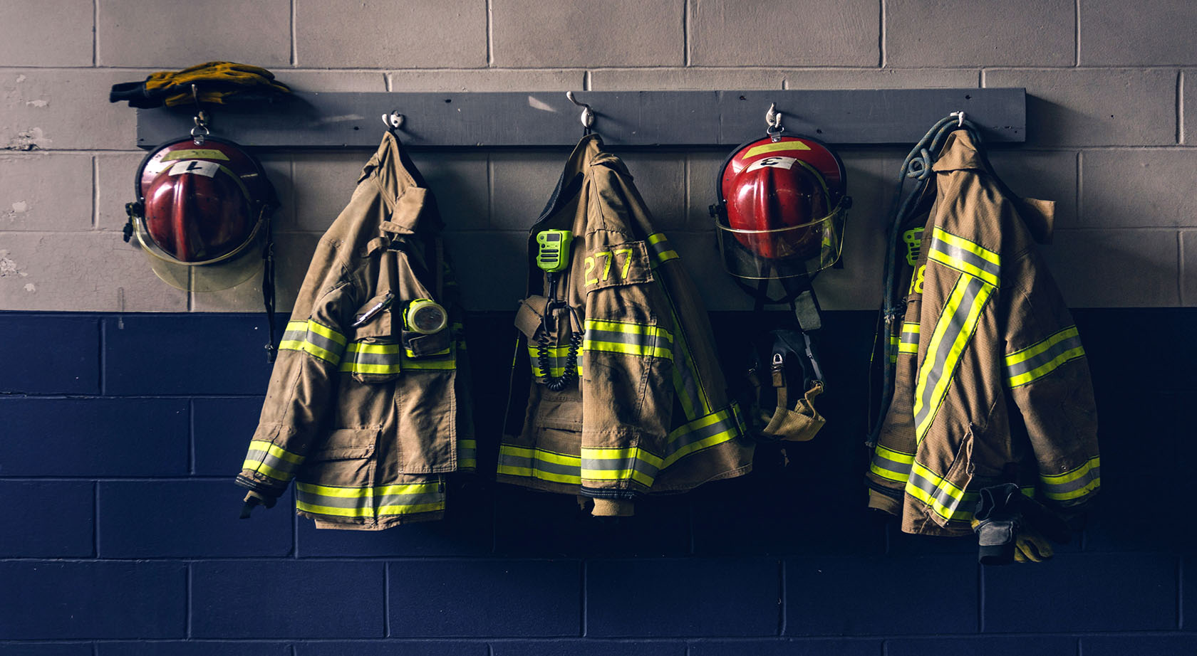 Firefighter jackets and helmets hanging on a wall