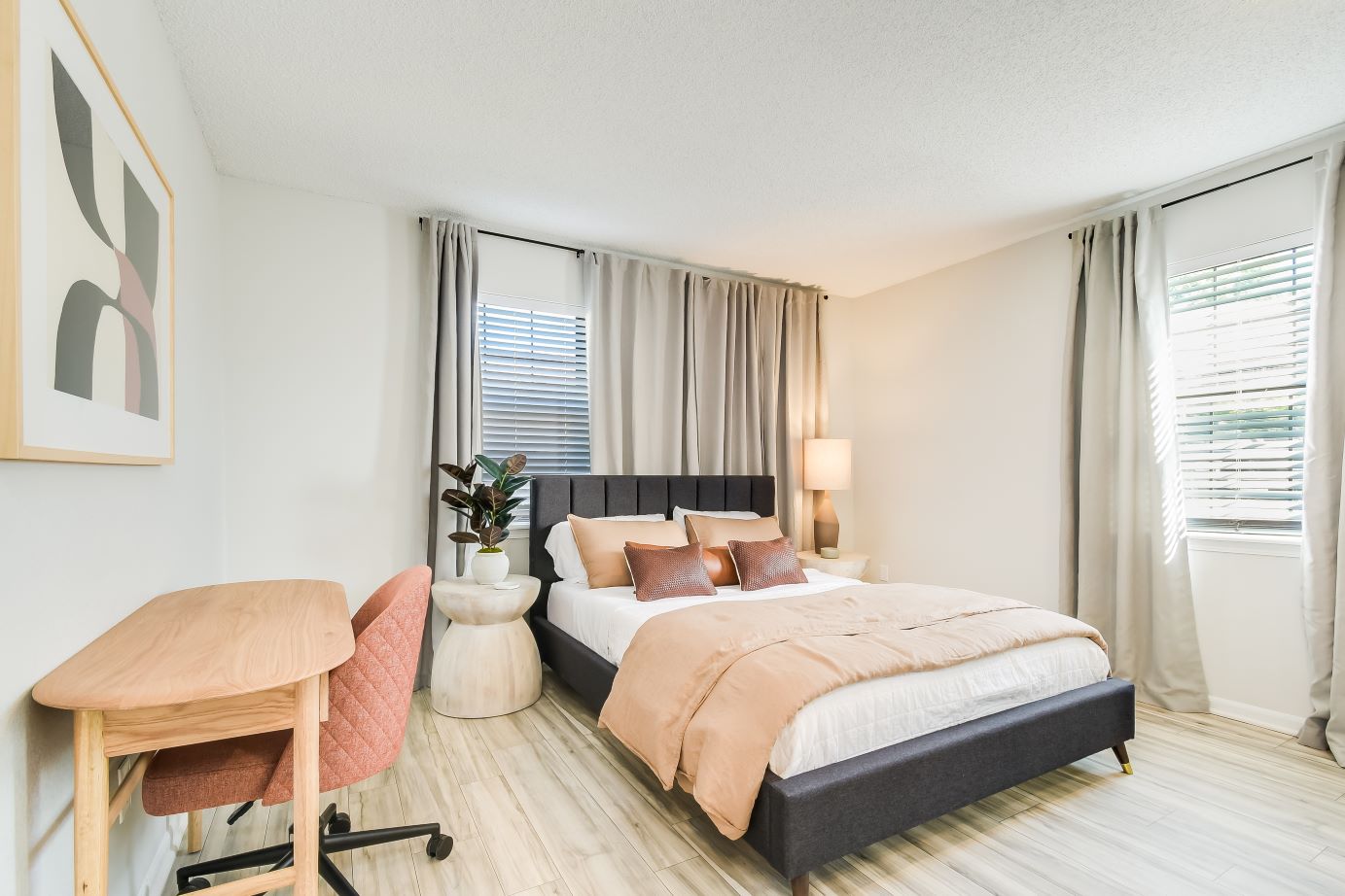A bedroom with a bed and a desk at The Arbor Apartments and Townhomes in Blue Springs, MO