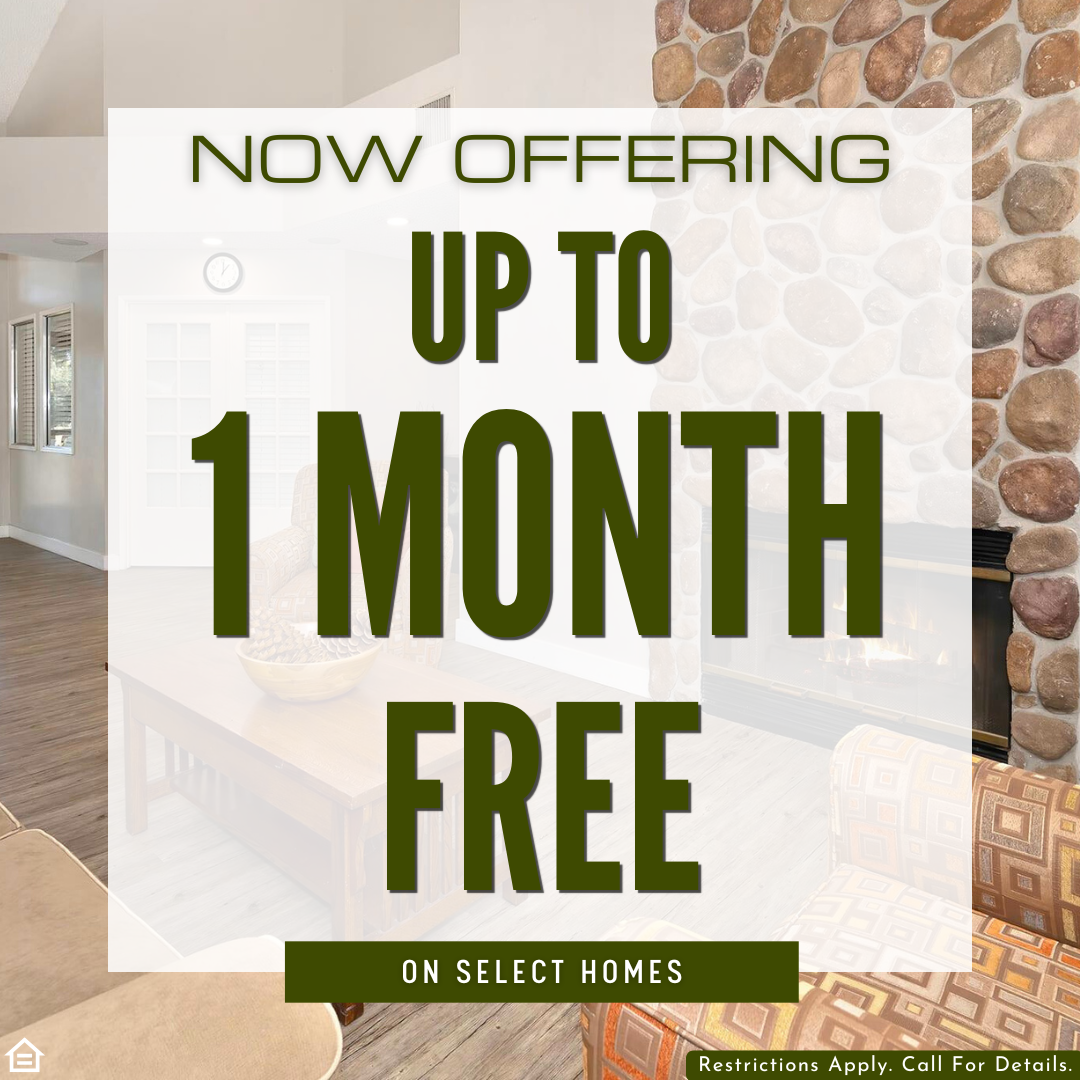 Promotional graphic showing a cozy apartment interior with a stone fireplace, wood flooring, and lounge seating. Large text in the center reads “Now Offering Up to 1 Month Free” with a smaller banner stating “On Select Homes.” A disclaimer at the bottom says “Restrictions apply. Call for details.”