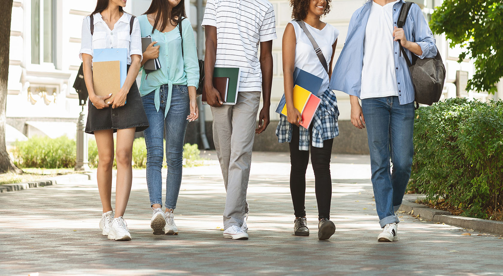 A group of students walking on a sidewalk