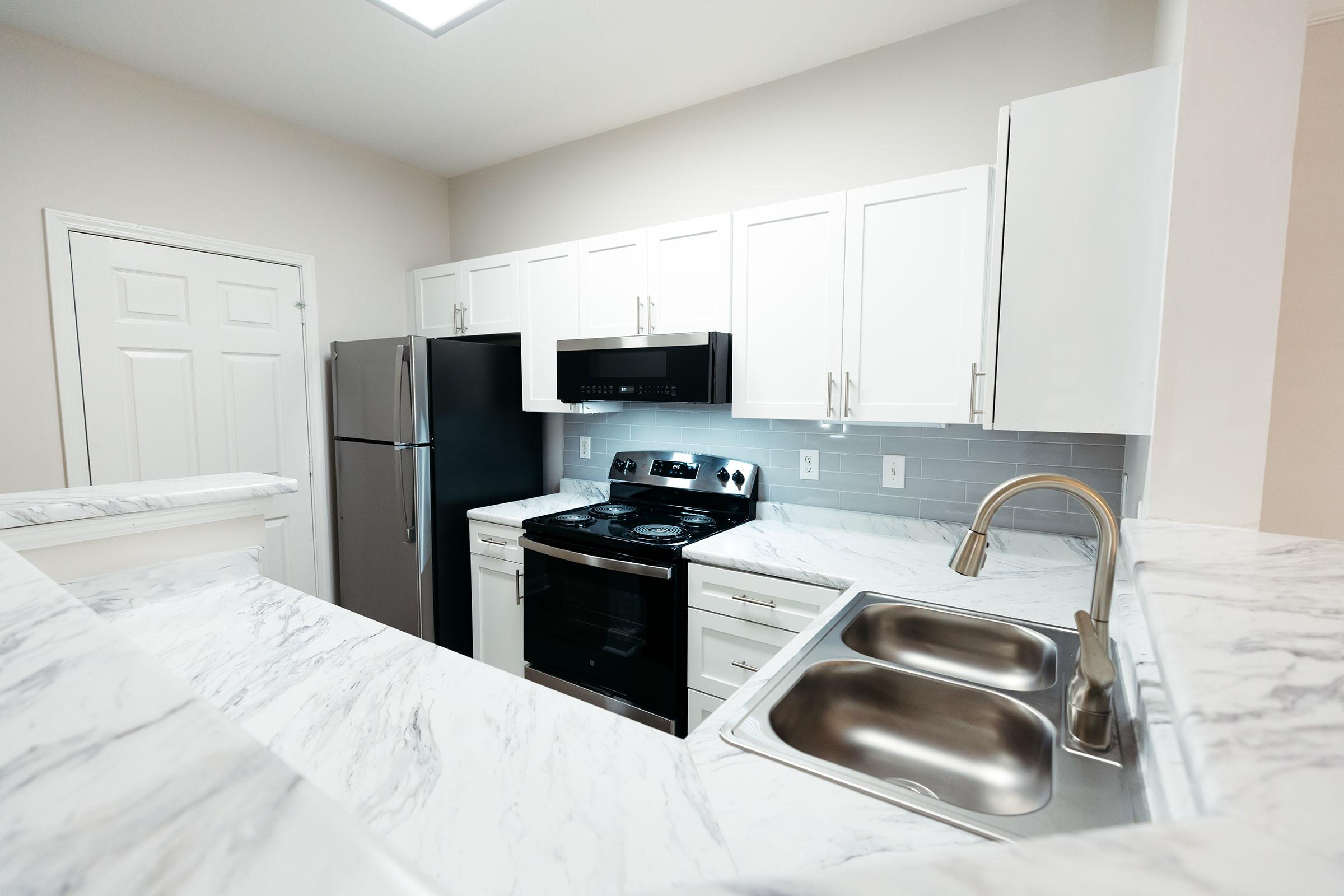 a kitchen with a sink and a bed