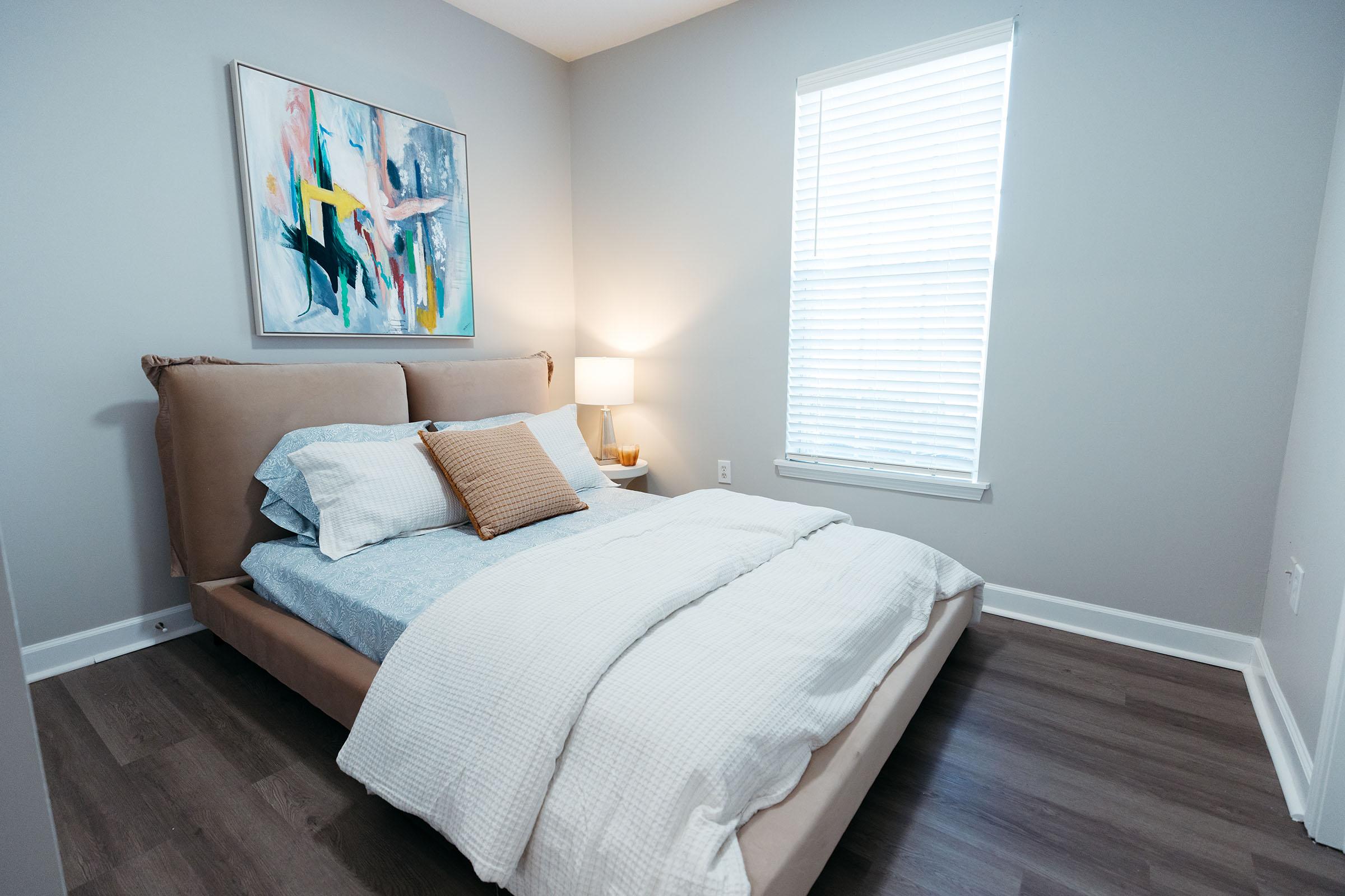 a bedroom with a bed and desk in a room