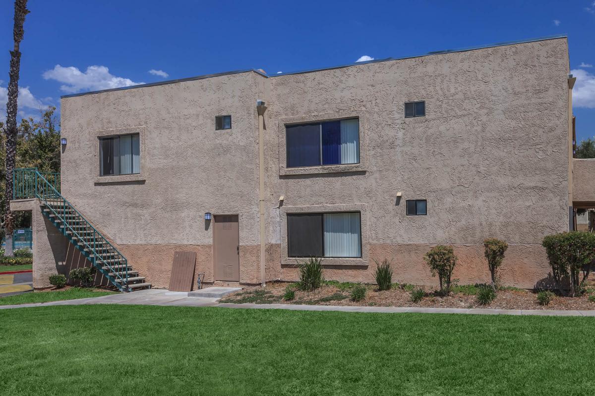 a large brick building with grass in front of a house