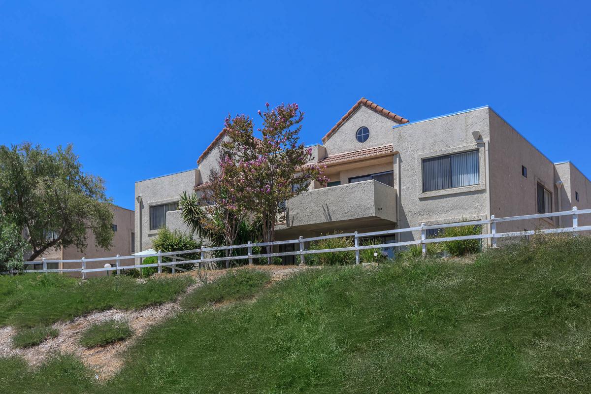 a large brick building with grass in front of a house