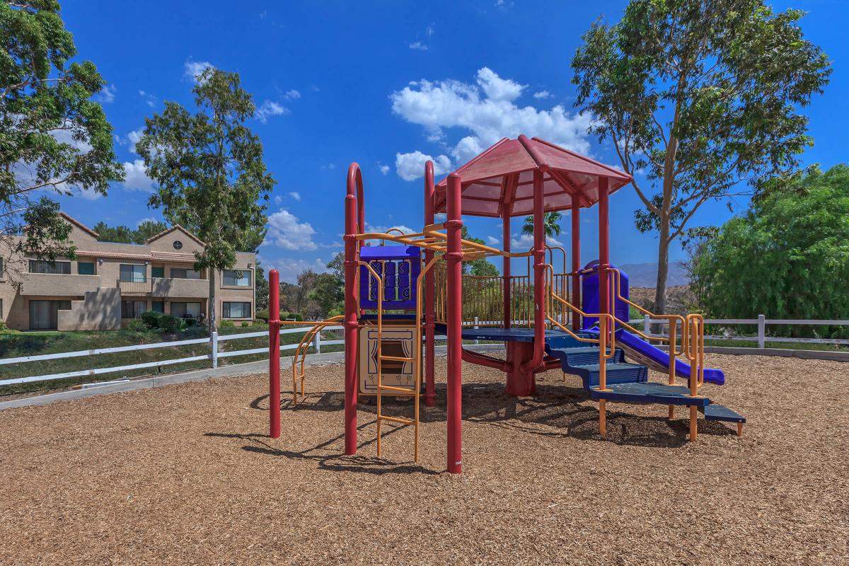 a playground with a blue umbrella