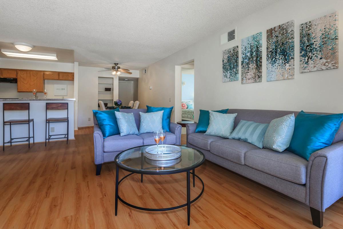 a living room filled with furniture on top of a hard wood floor