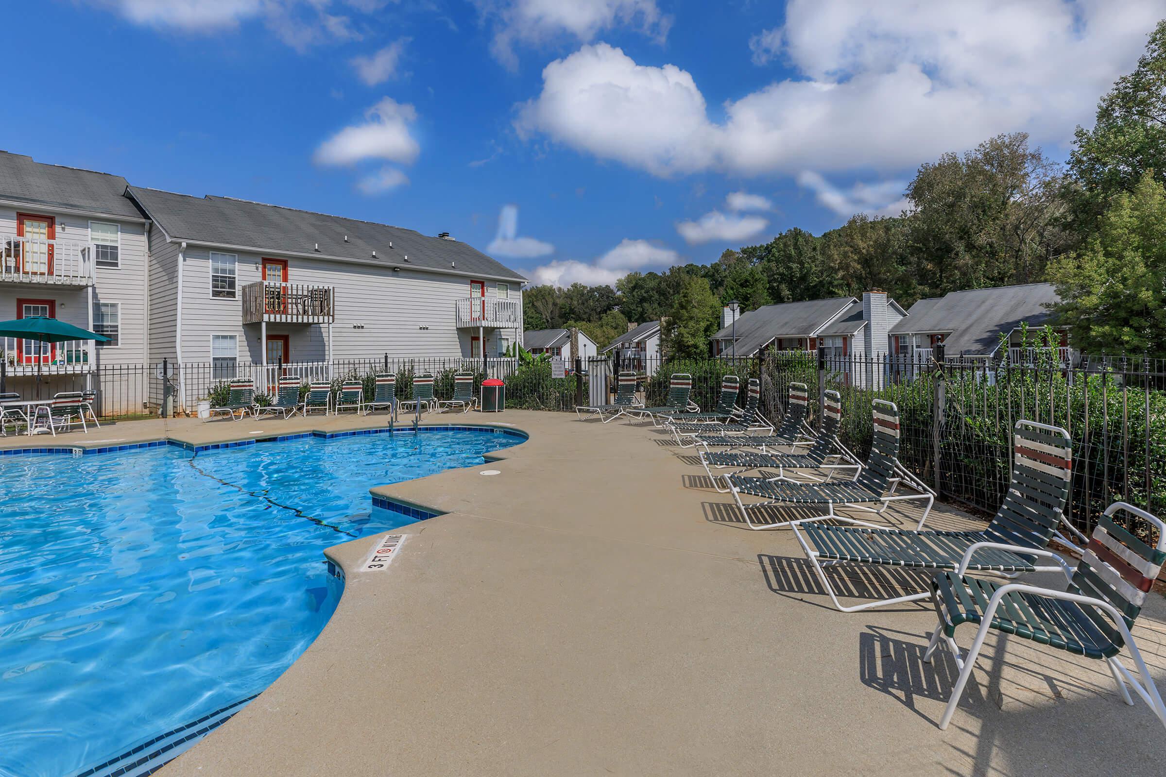 a group of lawn chairs sitting next to a pool of water