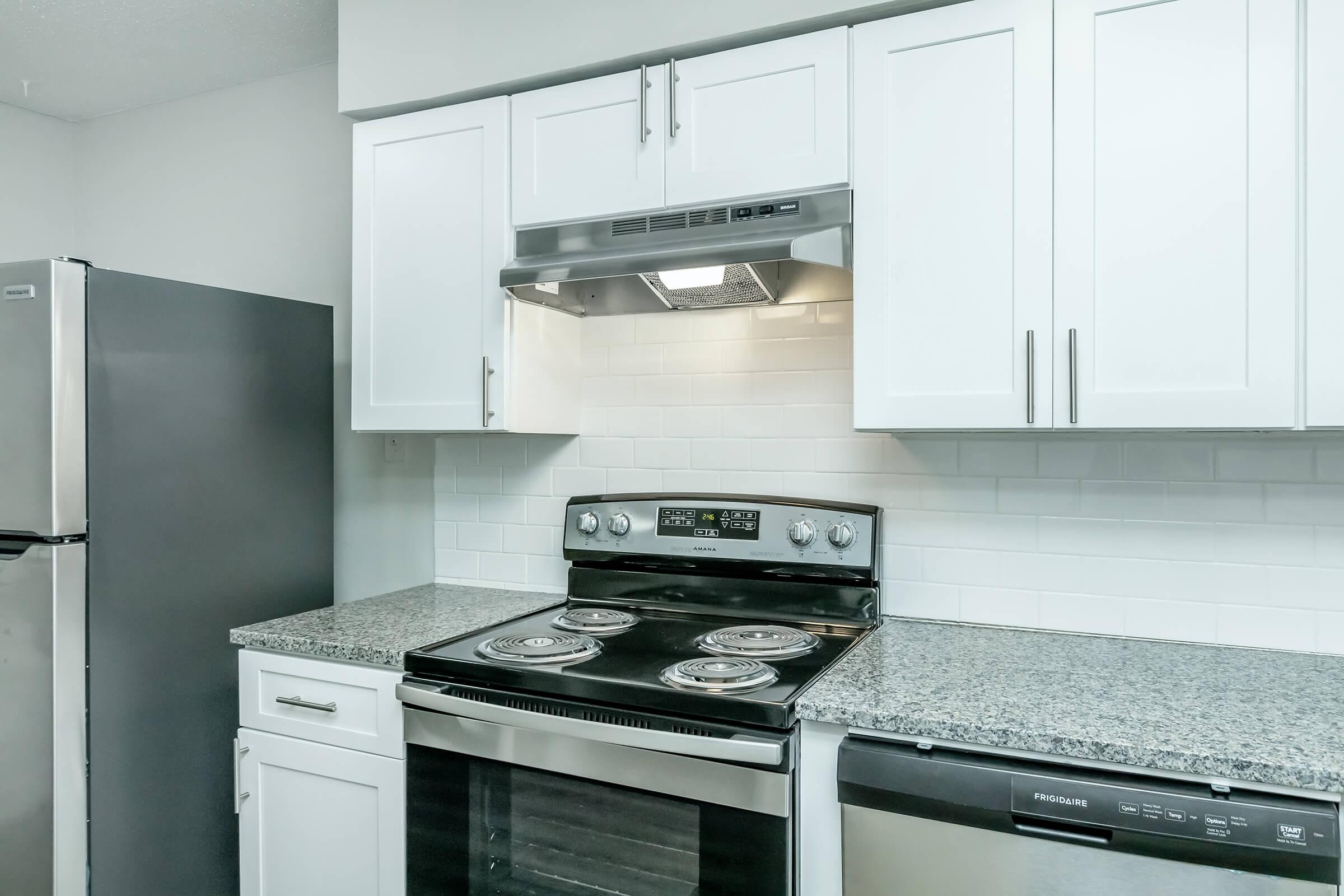 a stove top oven sitting inside of a kitchen