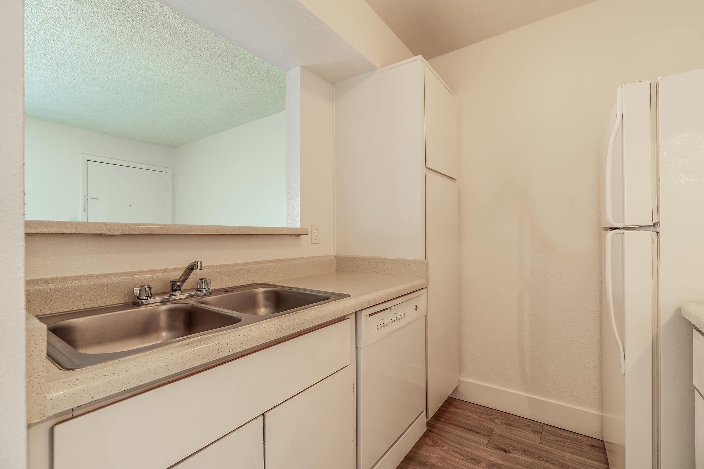 All white kitchen with white cabinets, white appliances, and grey countertops