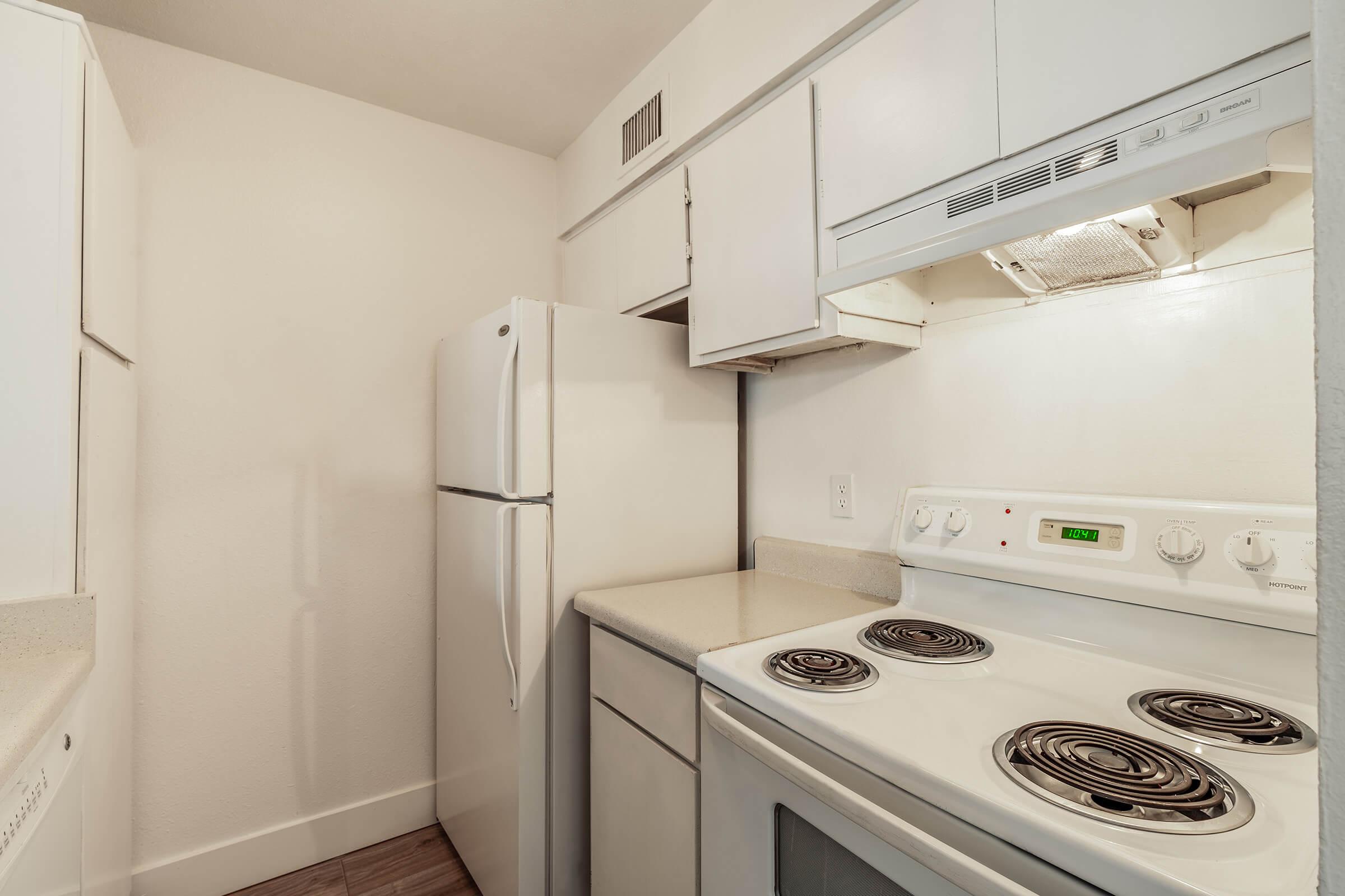 All white kitchen with white cabinets, white appliances, and grey countertops