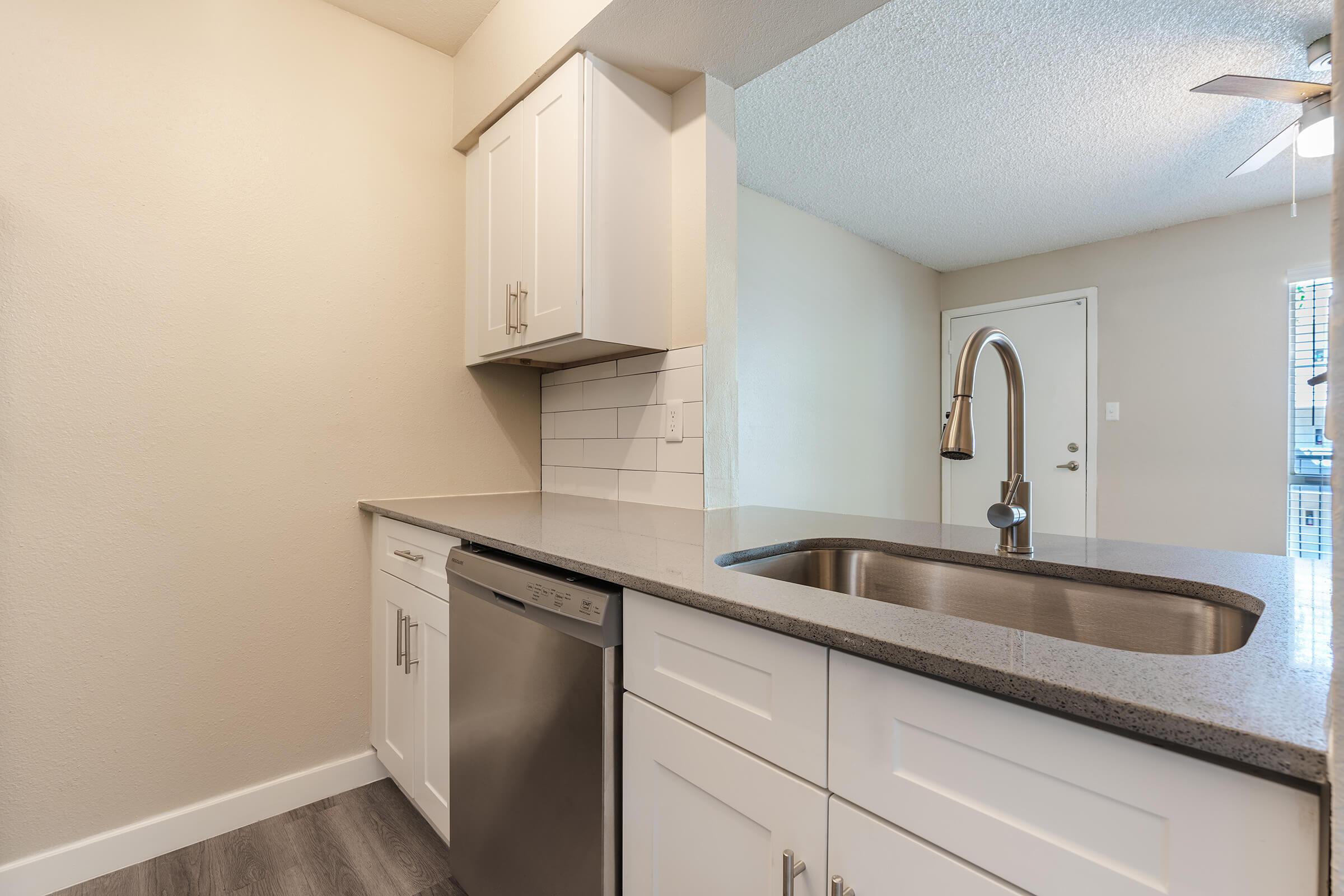 Modern renovated kitchen with white shaker cabinets and stainless steel appliances