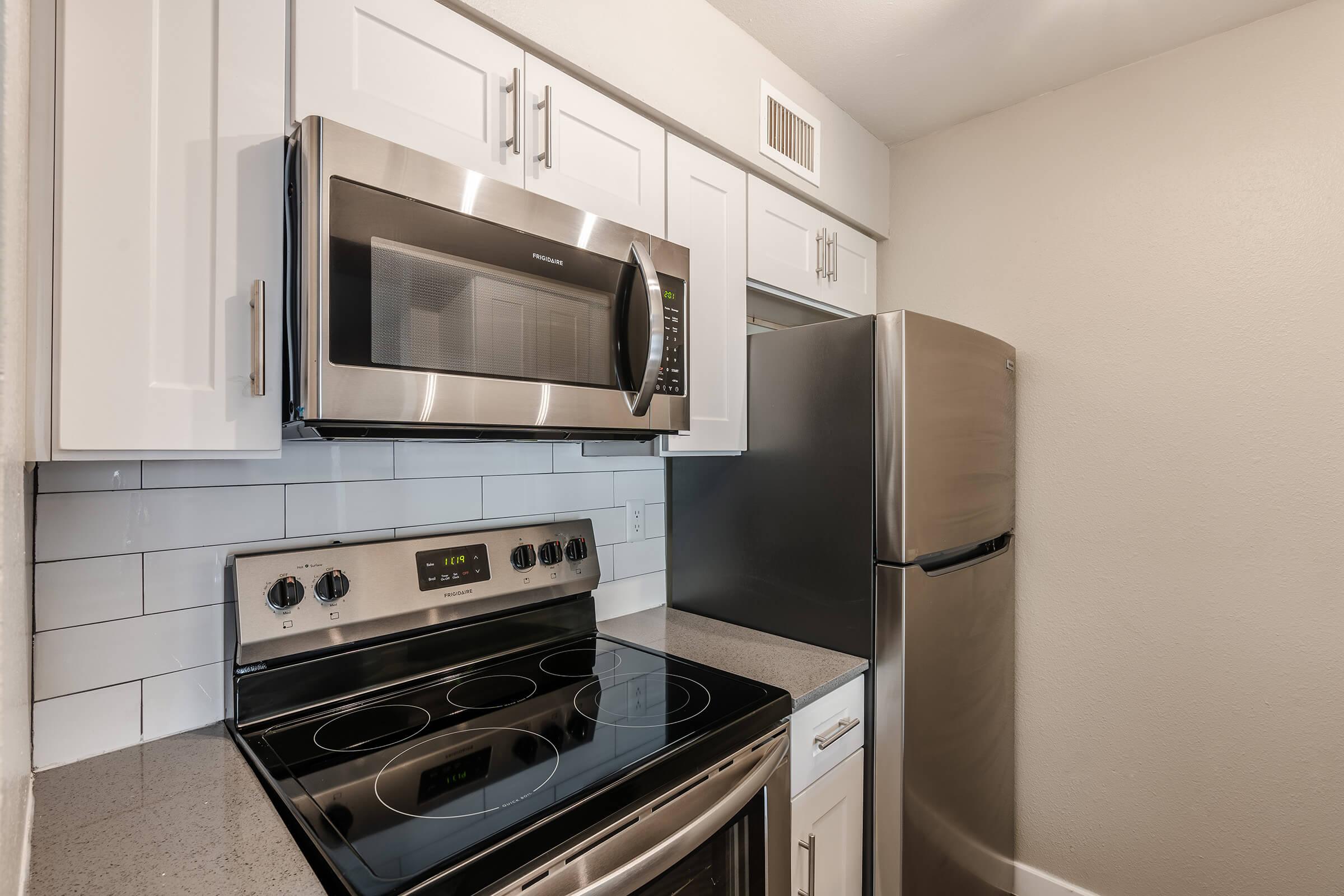 Modern renovated kitchen with white shaker cabinets and stainless steel appliances