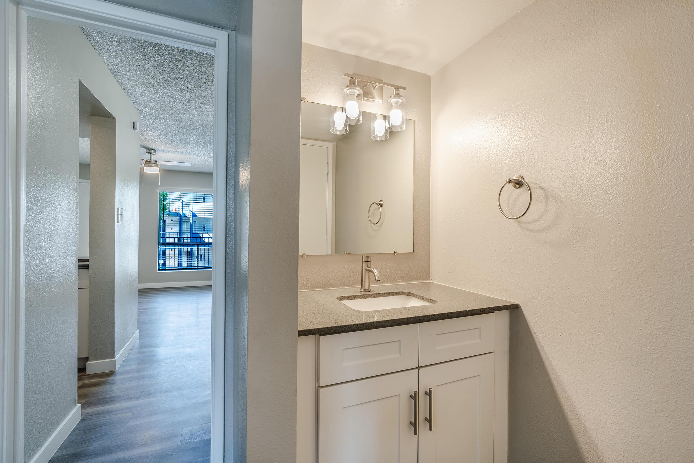 Bathroom with white cabinet vanity, mirror, and lighting fixture