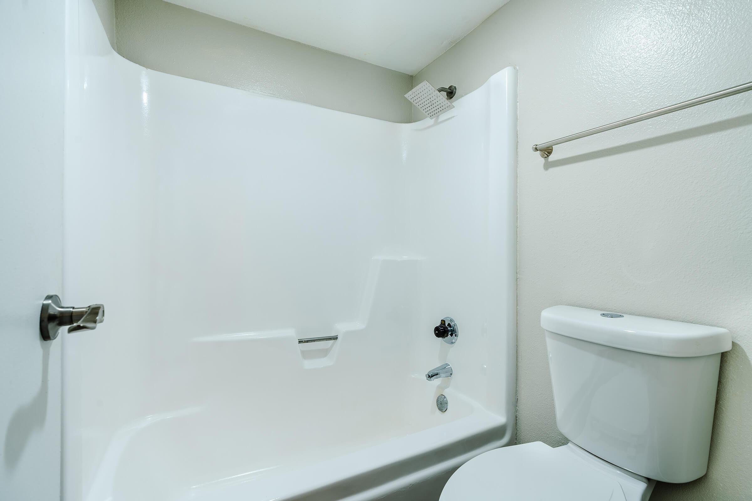 Close up view of a white shower tub and toilet