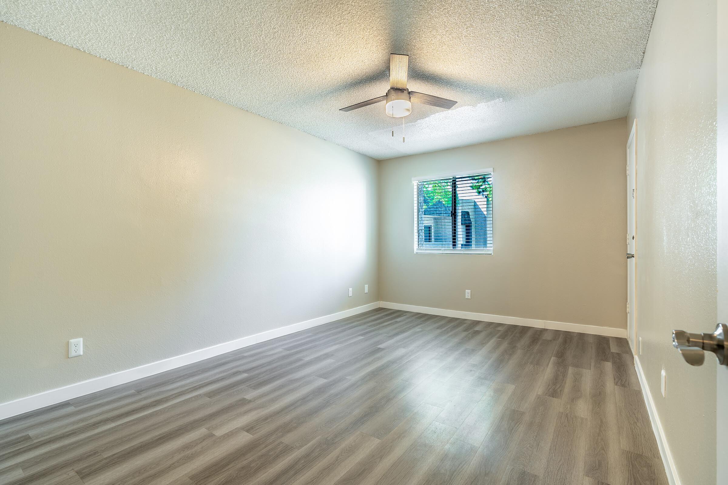 Large bedroom with window and ceiling fan