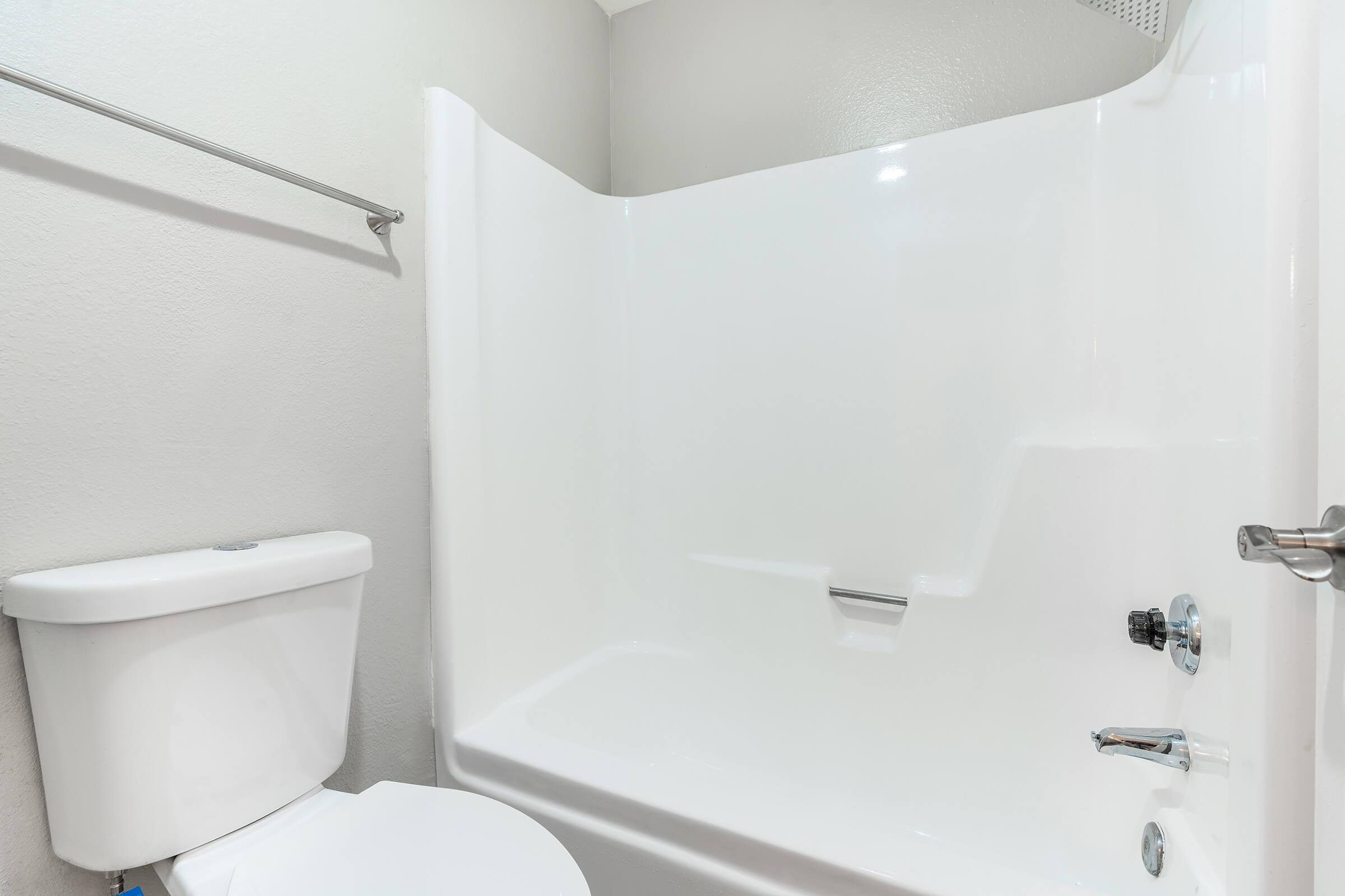 Close up view of a white shower tub and toilet