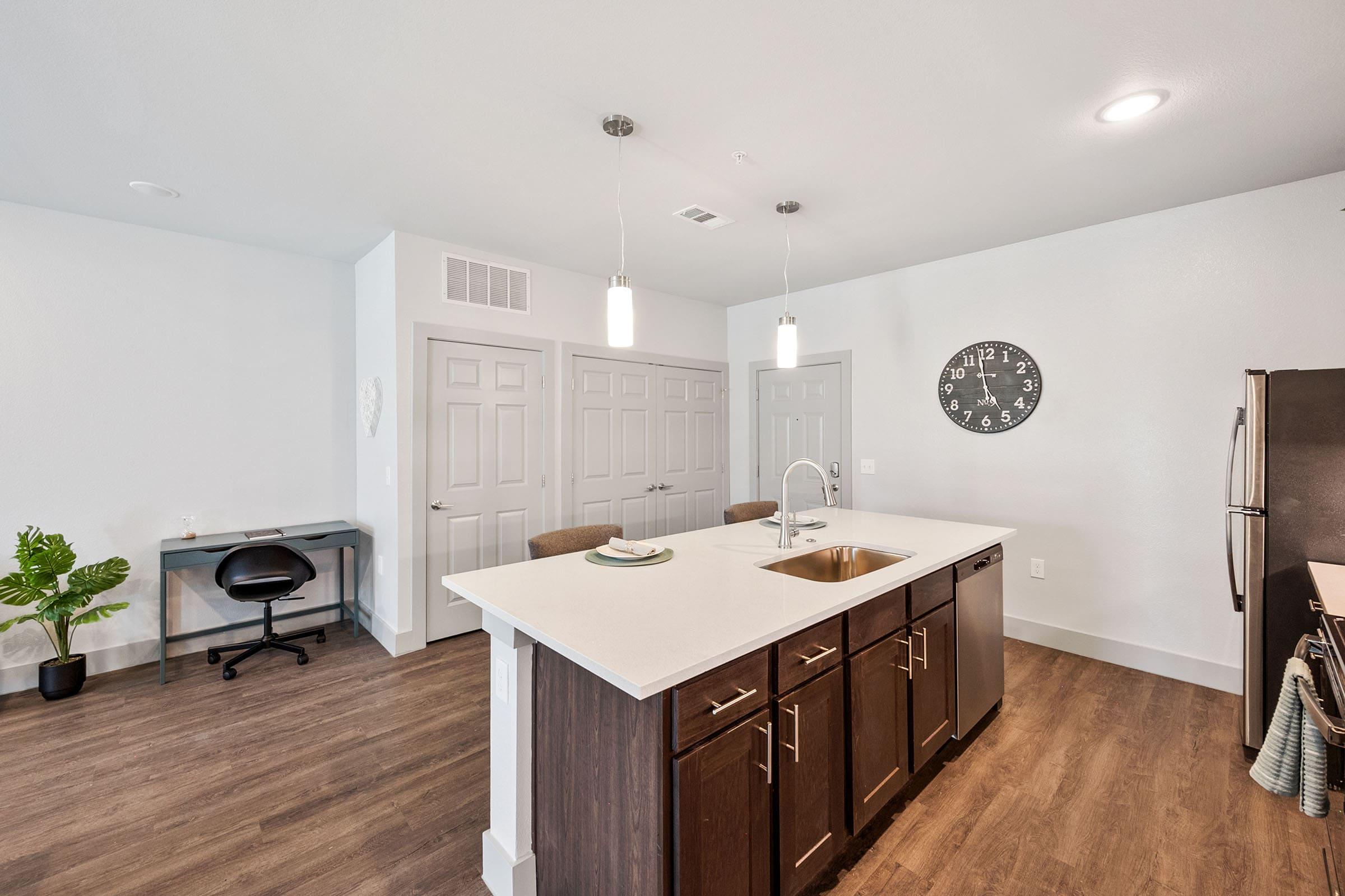 a kitchen with a sink and a mirror in a room