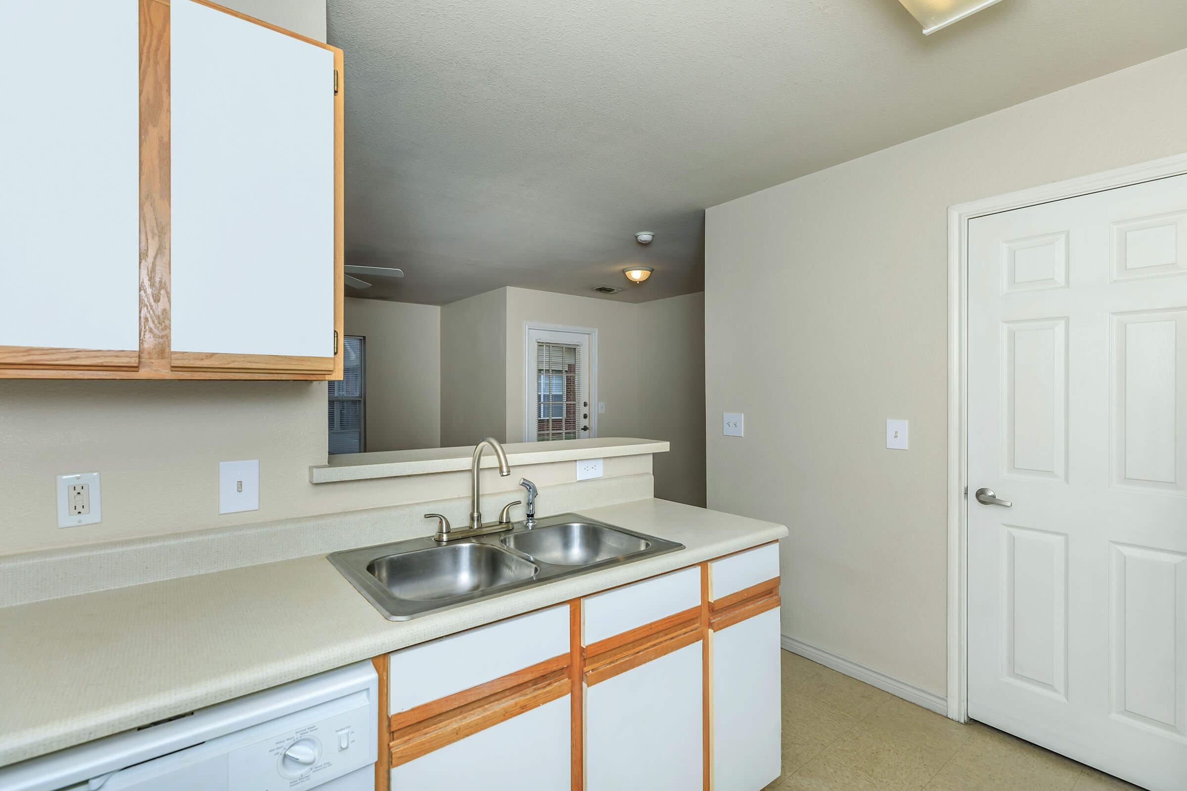 a kitchen with a sink and a mirror