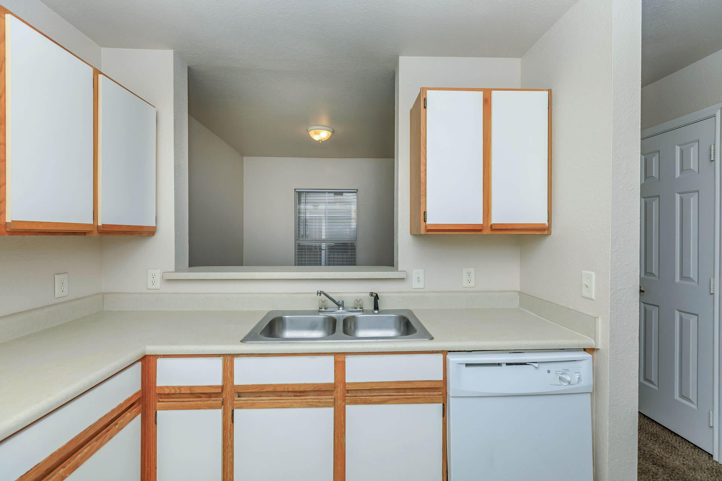 a kitchen with a sink and a mirror