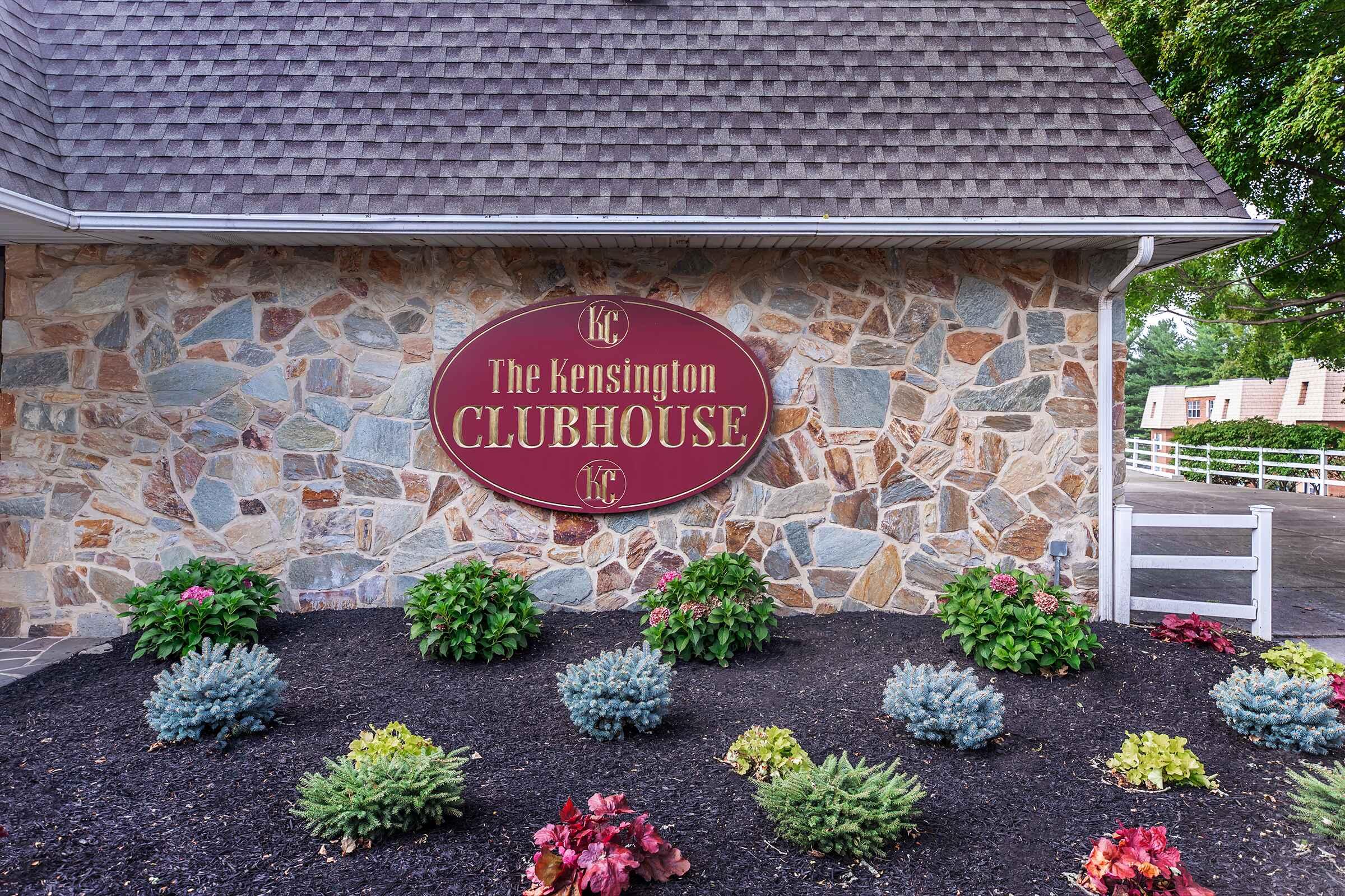 a close up of a flower garden in front of a brick building