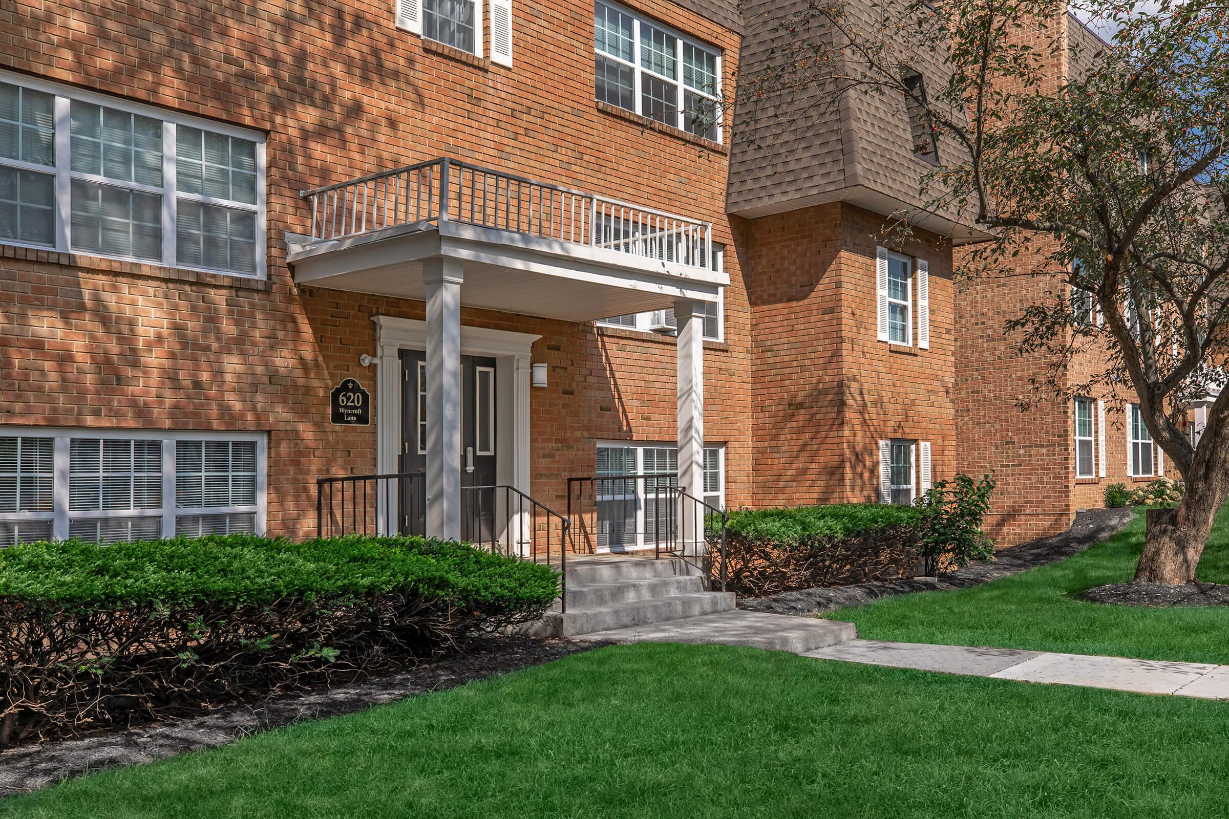 a large lawn in front of a brick building