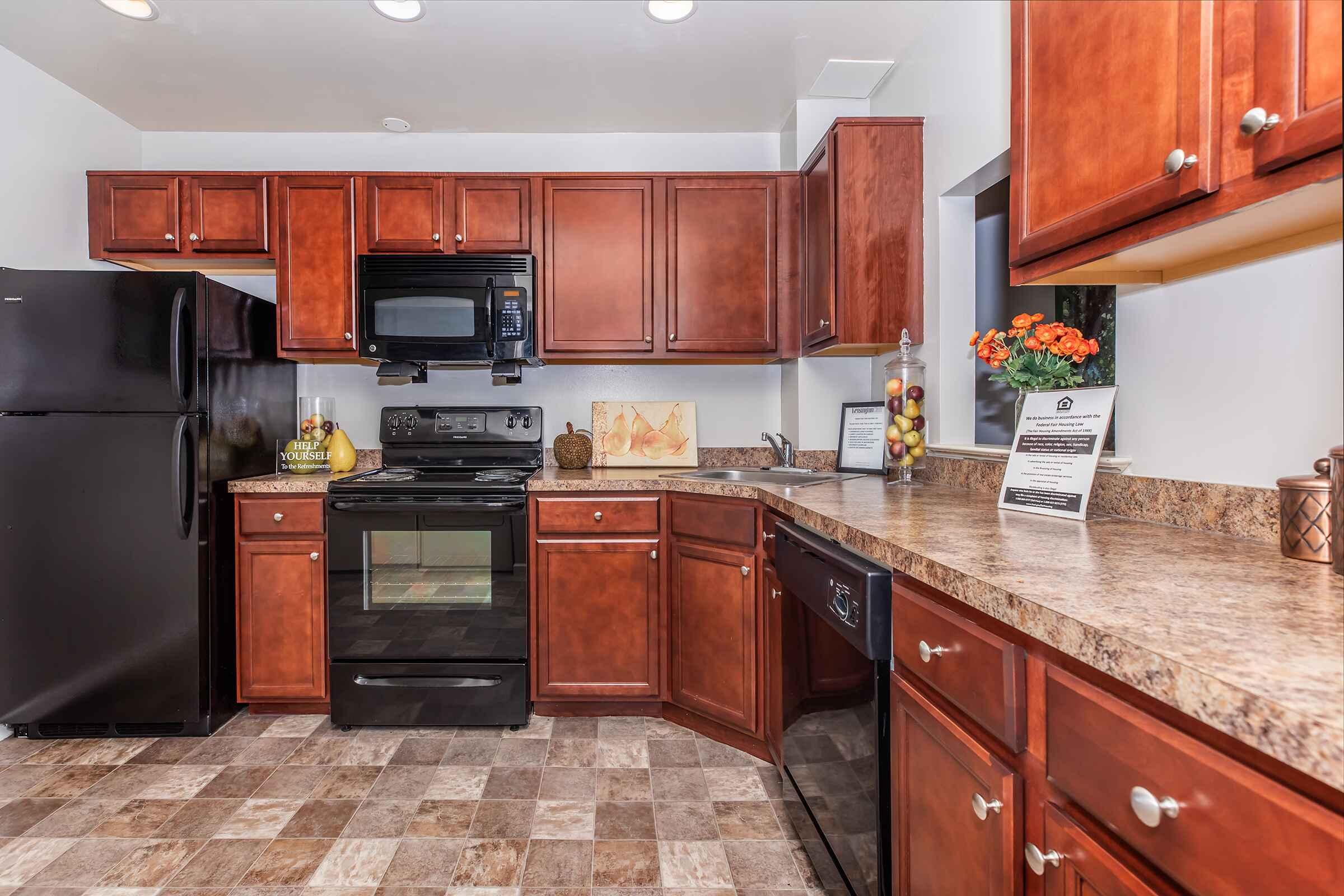 a large kitchen with stainless steel appliances and wooden cabinets