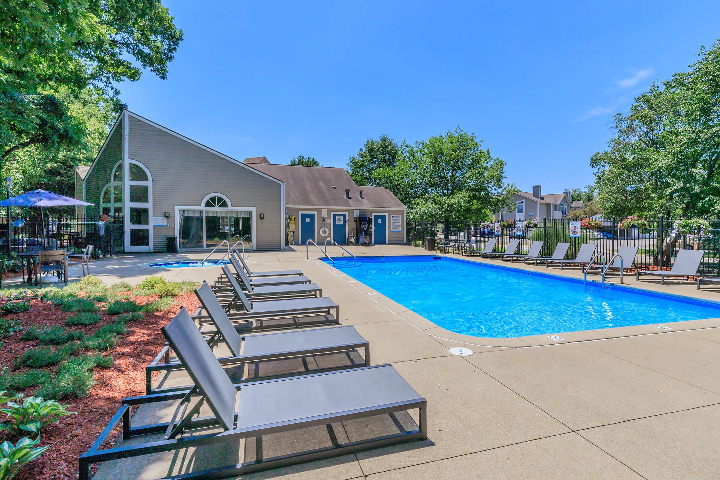 a row of lawn chairs sitting next to a pool of water