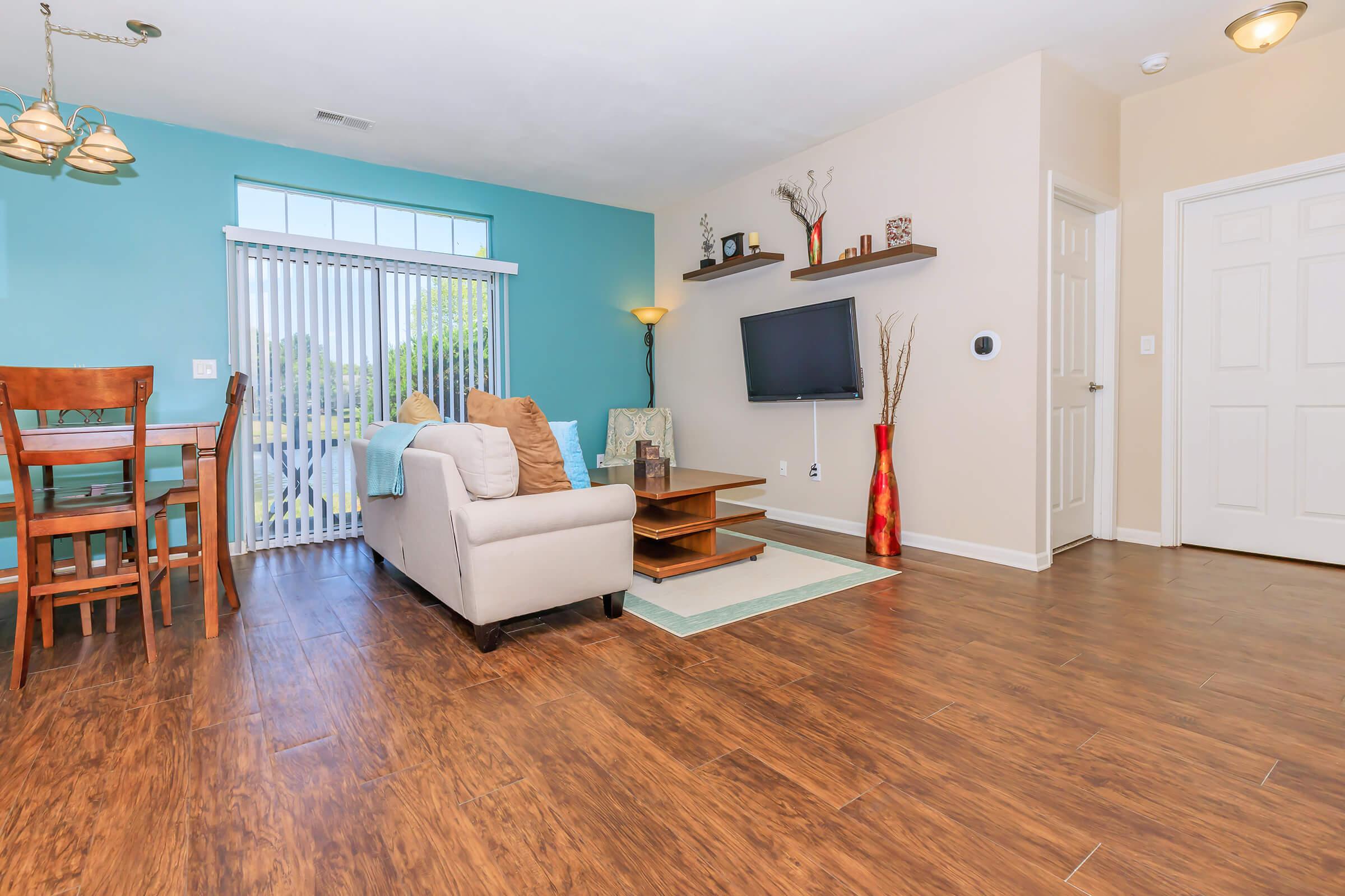 a living room filled with furniture and a wood floor
