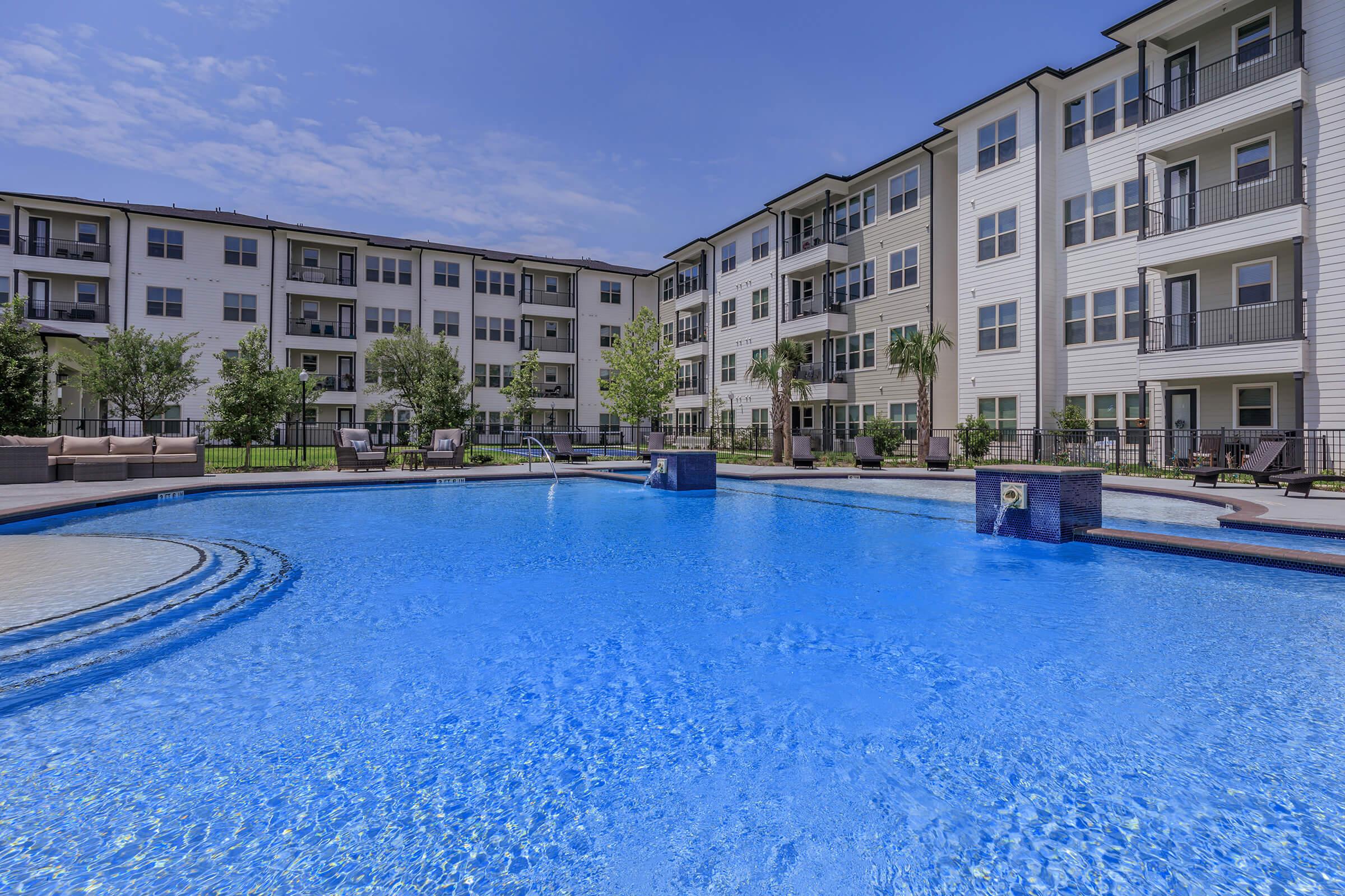 a blue pool of water in front of a building