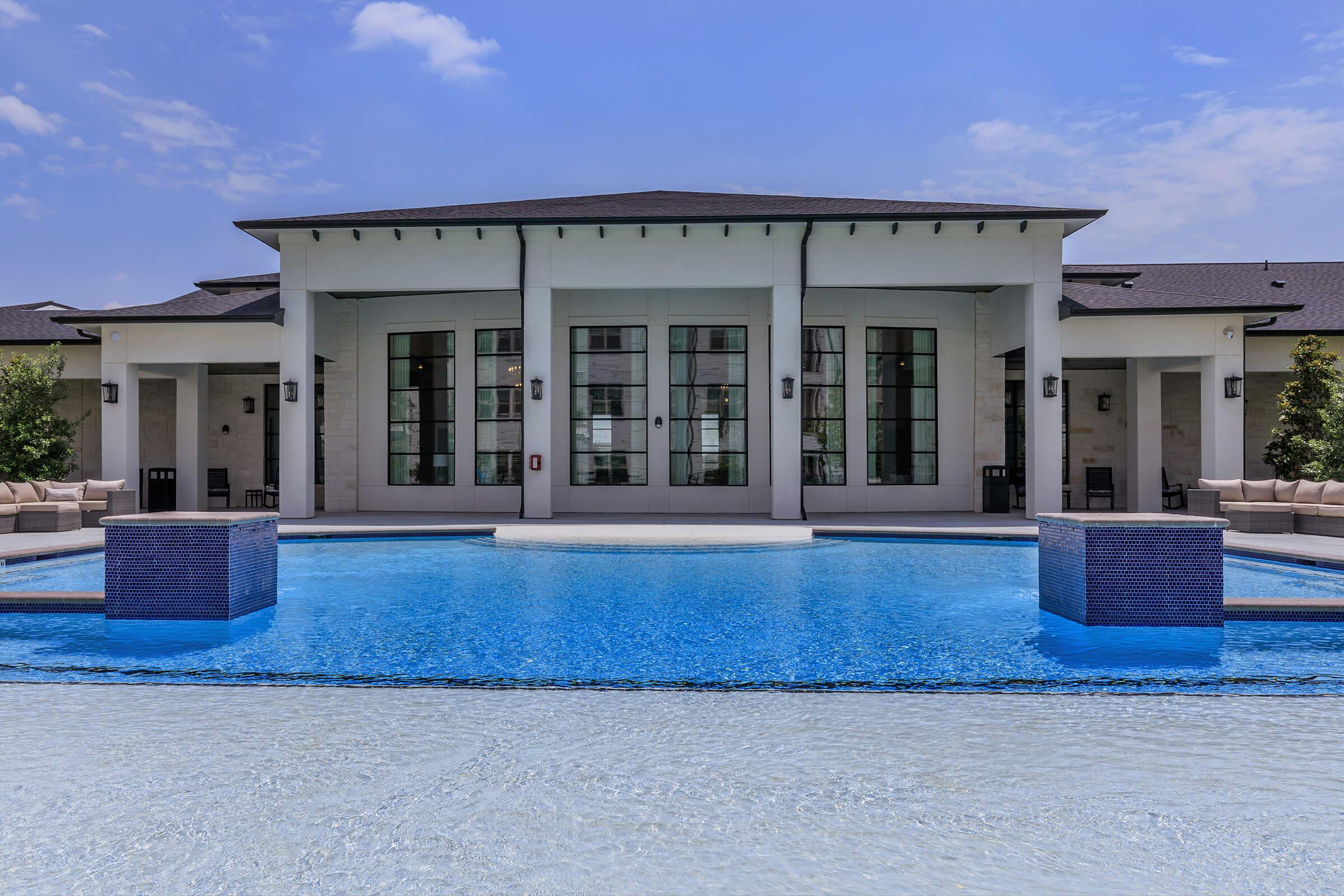 a blue pool of water in front of a house