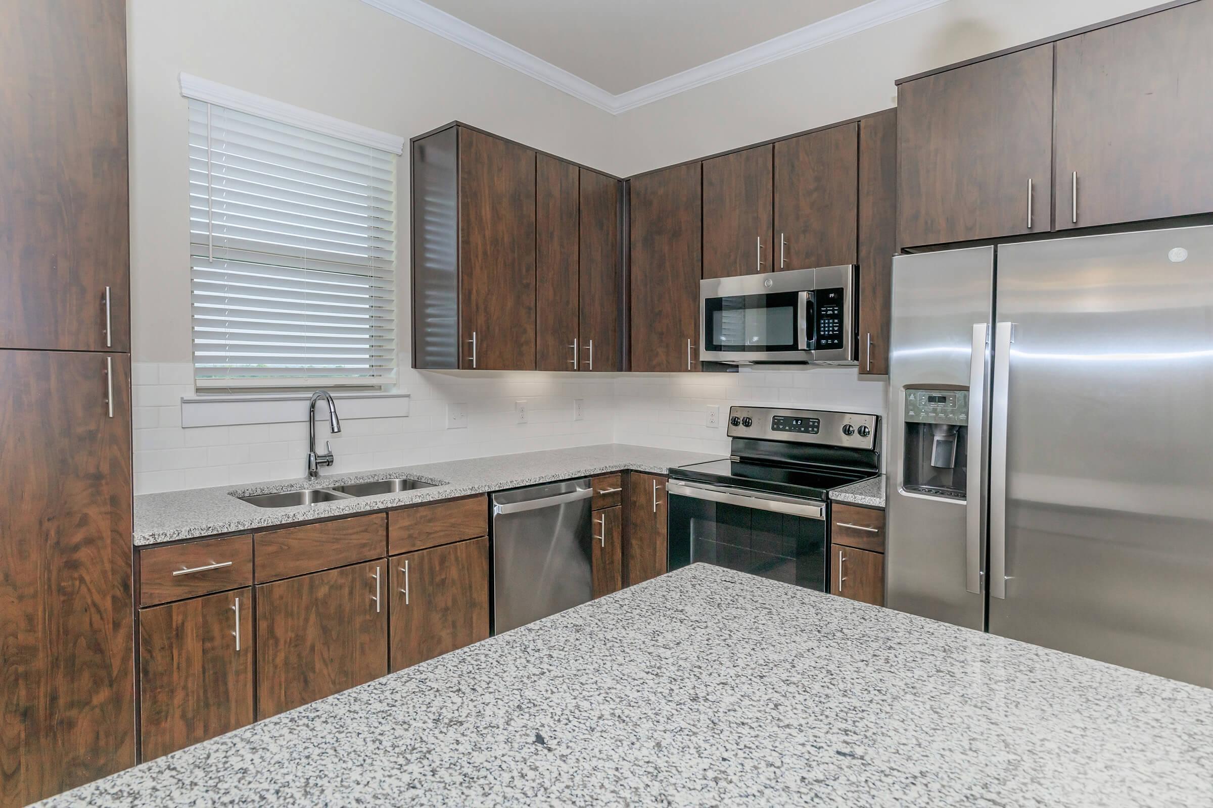 a modern kitchen with stainless steel appliances and wooden cabinets